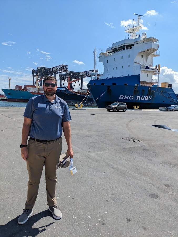 Sean Dirscherl stands in front of a cargo ship