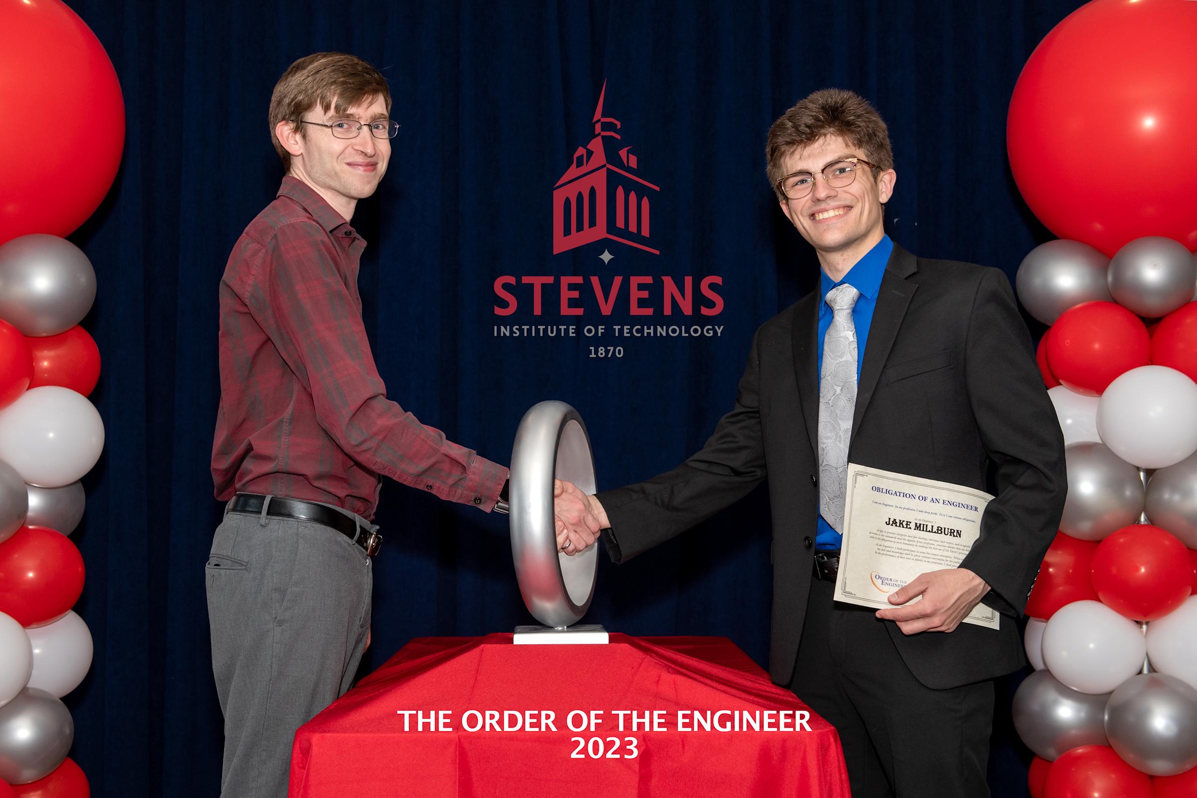 Jake Millburn ‘23 receives his ring and shakes hands with facilitator.