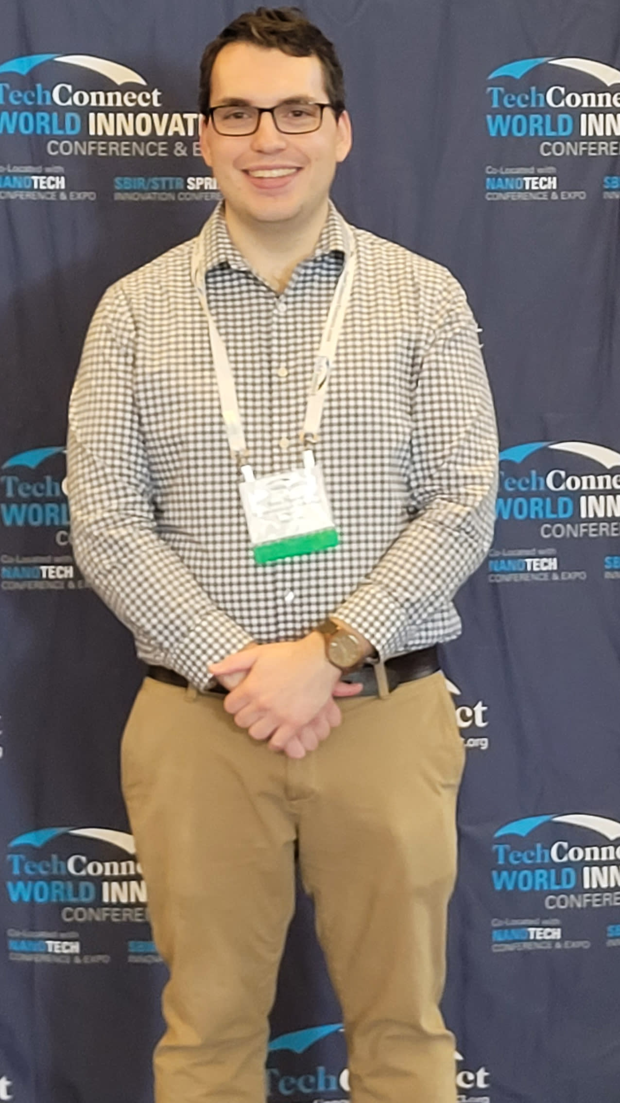 Scott Ruppel standing in front of a background at a convention