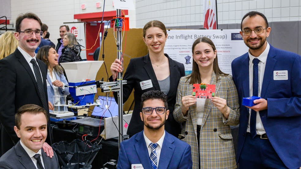 Team members and their drone-battery swapping display at the 2023 Stevens Innovation Expo