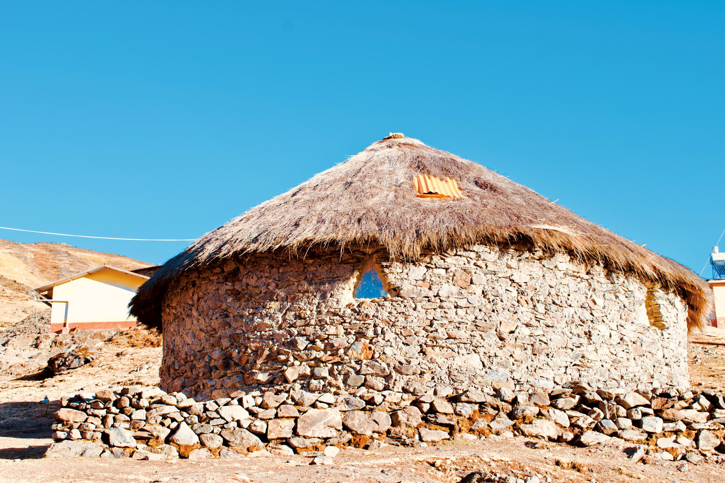 A circular stone building on a hill in Peru.