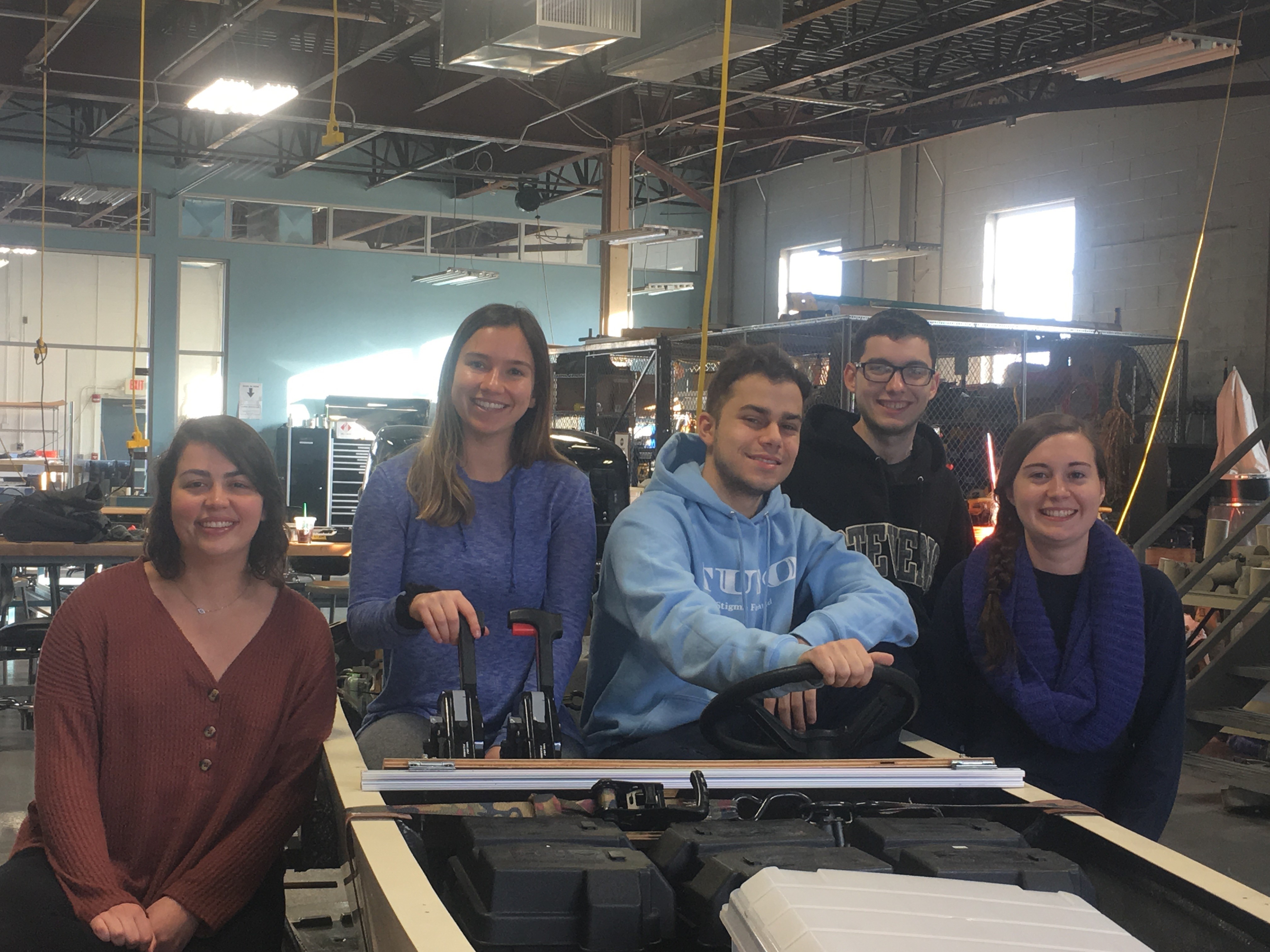 From left to right: Stevens' Solar Splash team members Victoria Davis ‘19, Melanie Valentin ‘19, Matthew Colacino ‘19, Justin Sitler ‘19 and Meghan Hand ‘19 pose around the competition boat inside the Griffith Building near Stevens campus