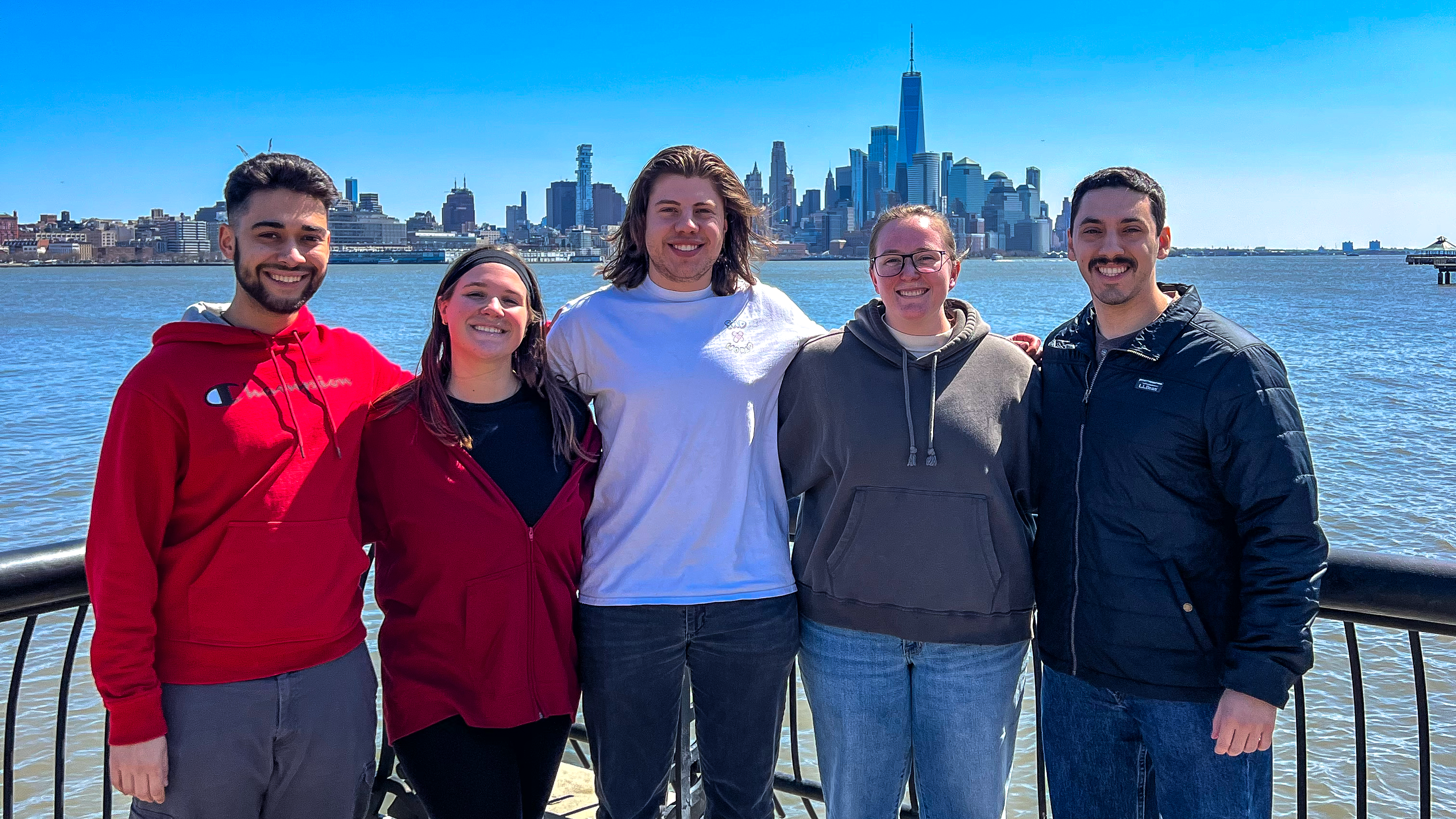 From left to right, Stevens students Bryan Rodriguez, Madison Kidd, Evan Cohen, Melanie Blarr and Mike Lanfranco pose on a bridge with the New York City skyline in the background.