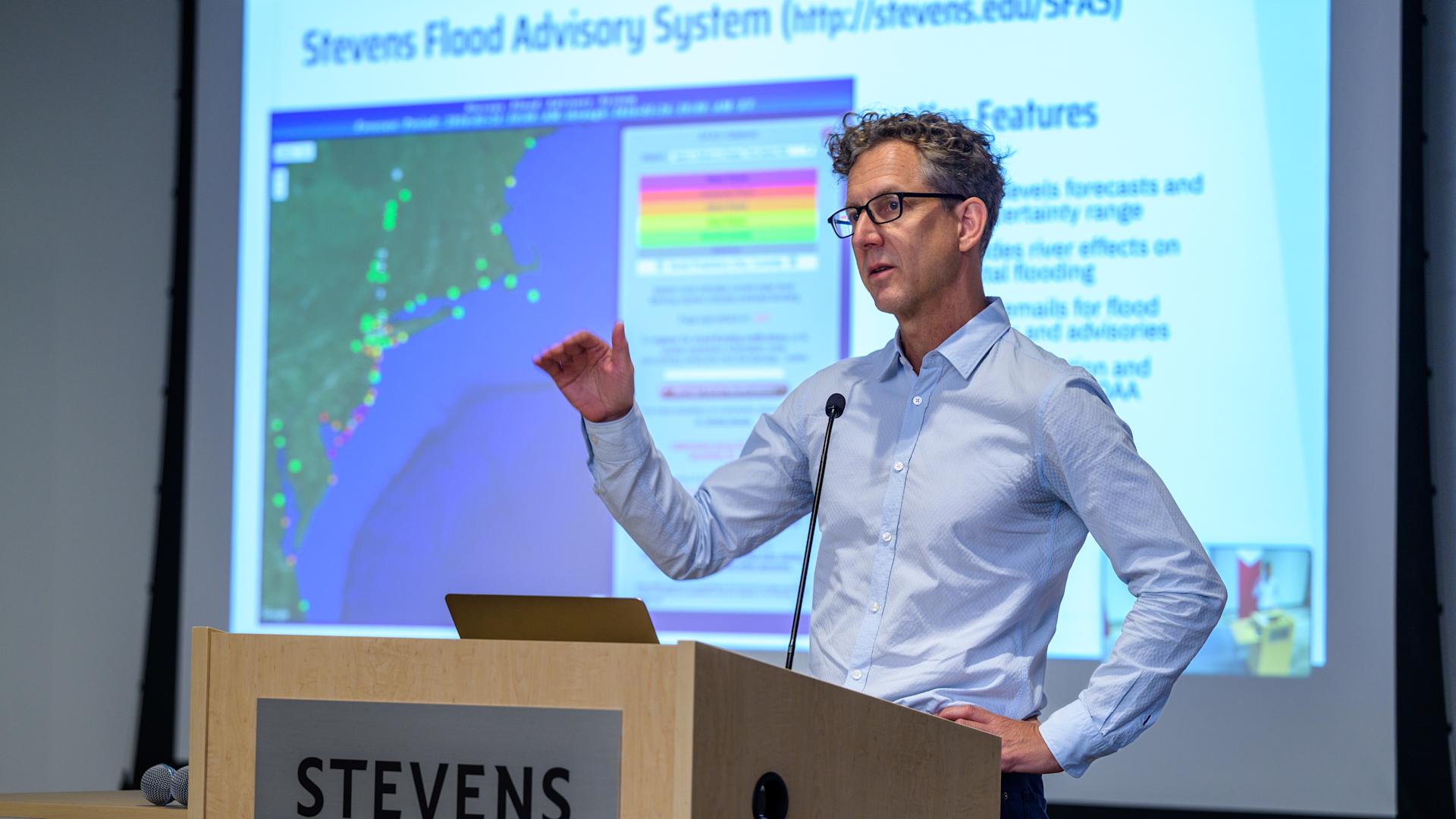 Stevens professor Philip Orton on a stage, presenting at a resilience conference