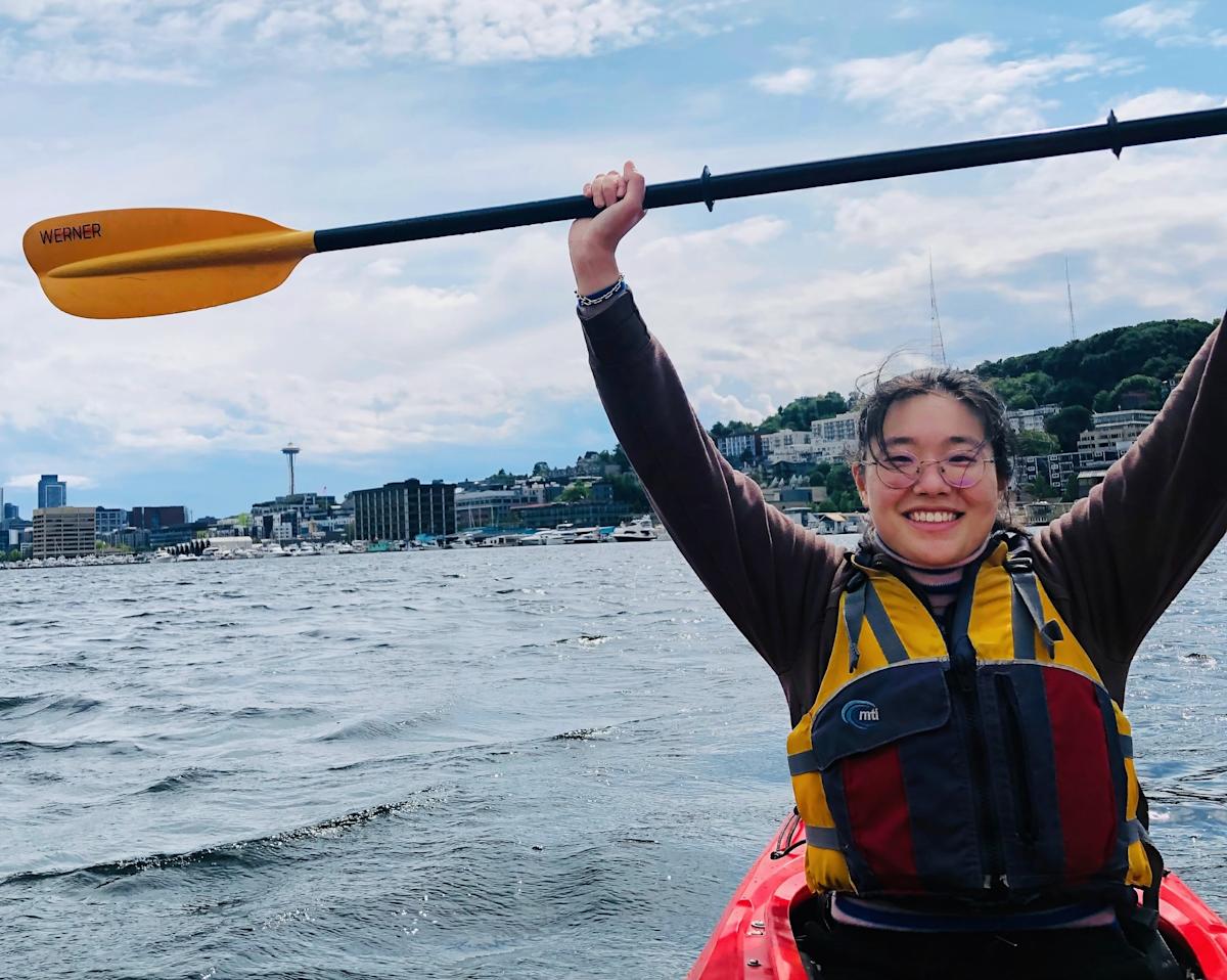 A photograph of Yewei Huang kayaking in a river.