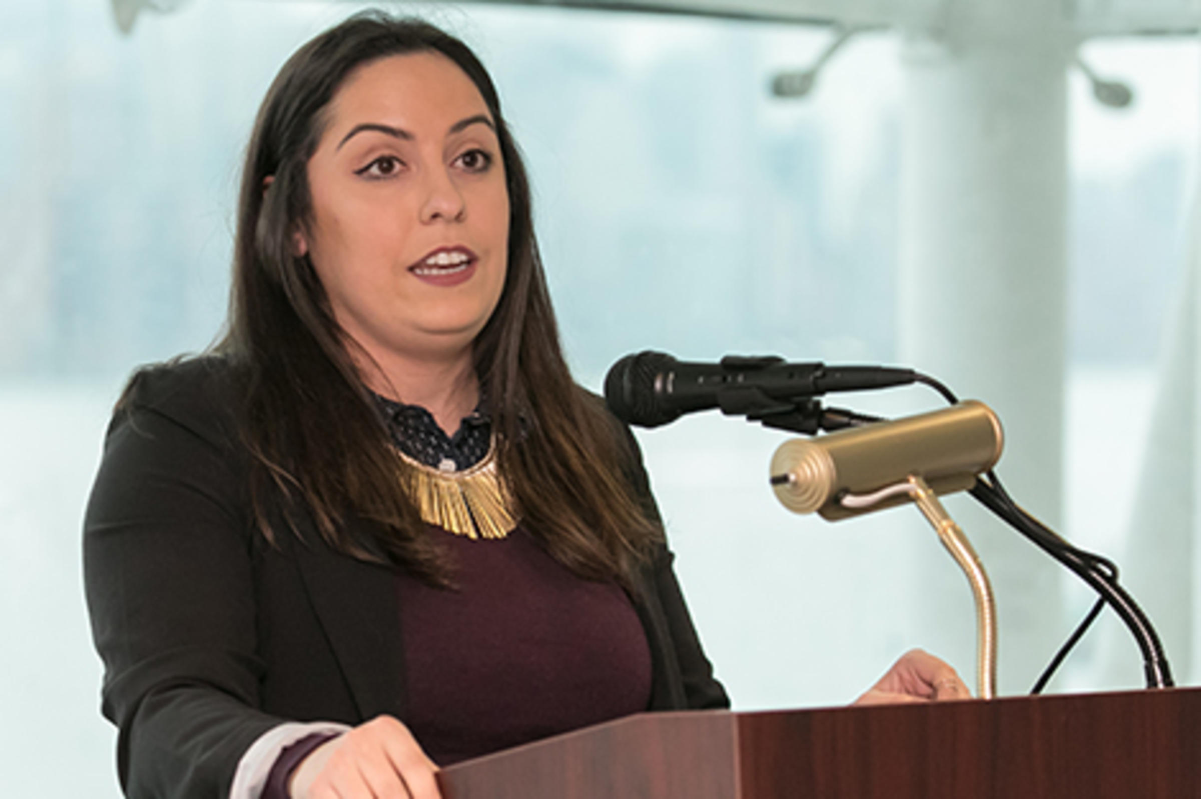 Krista Sticco speaks at a podium.
