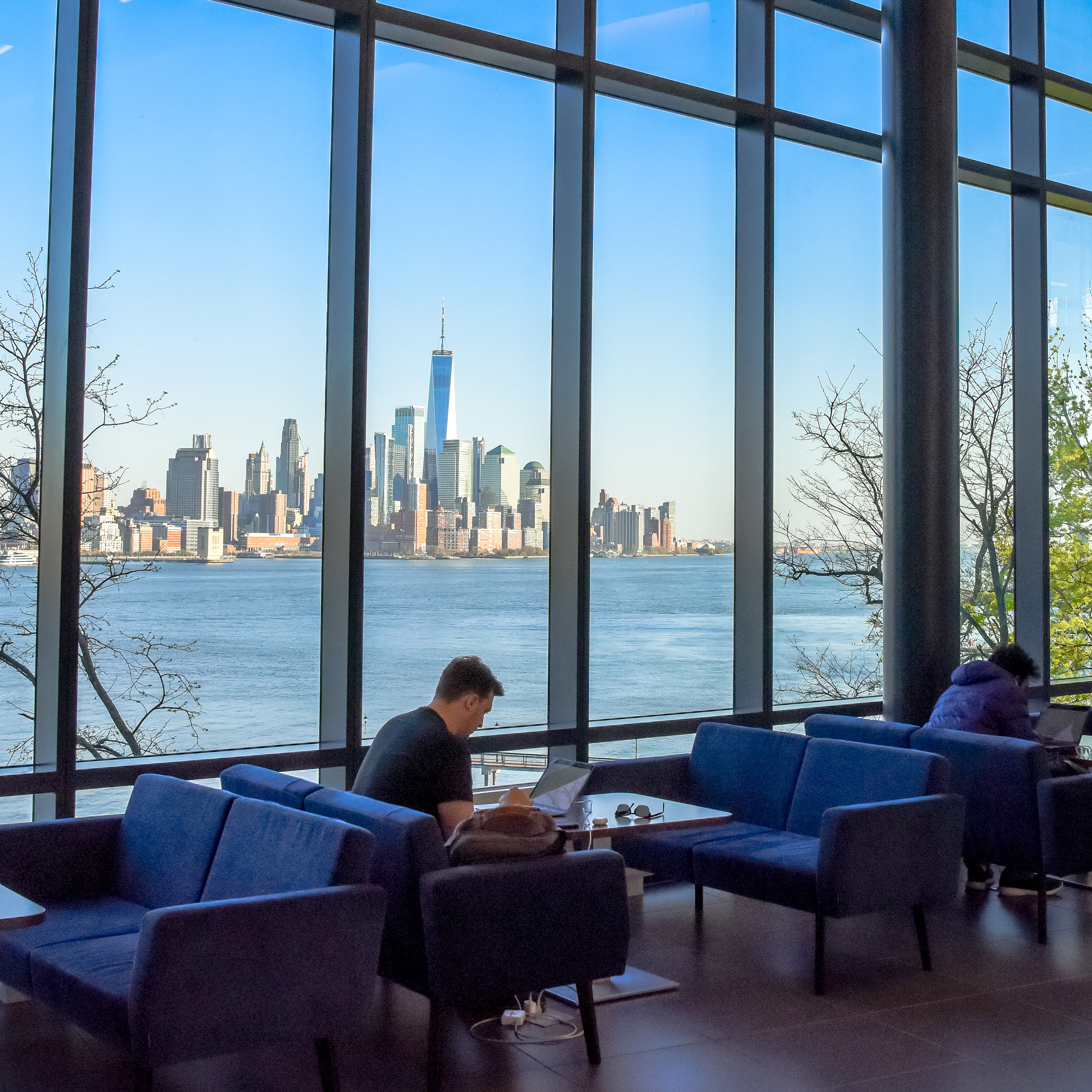 Student studying inside the UCC with the Manhattan skyline in the background.