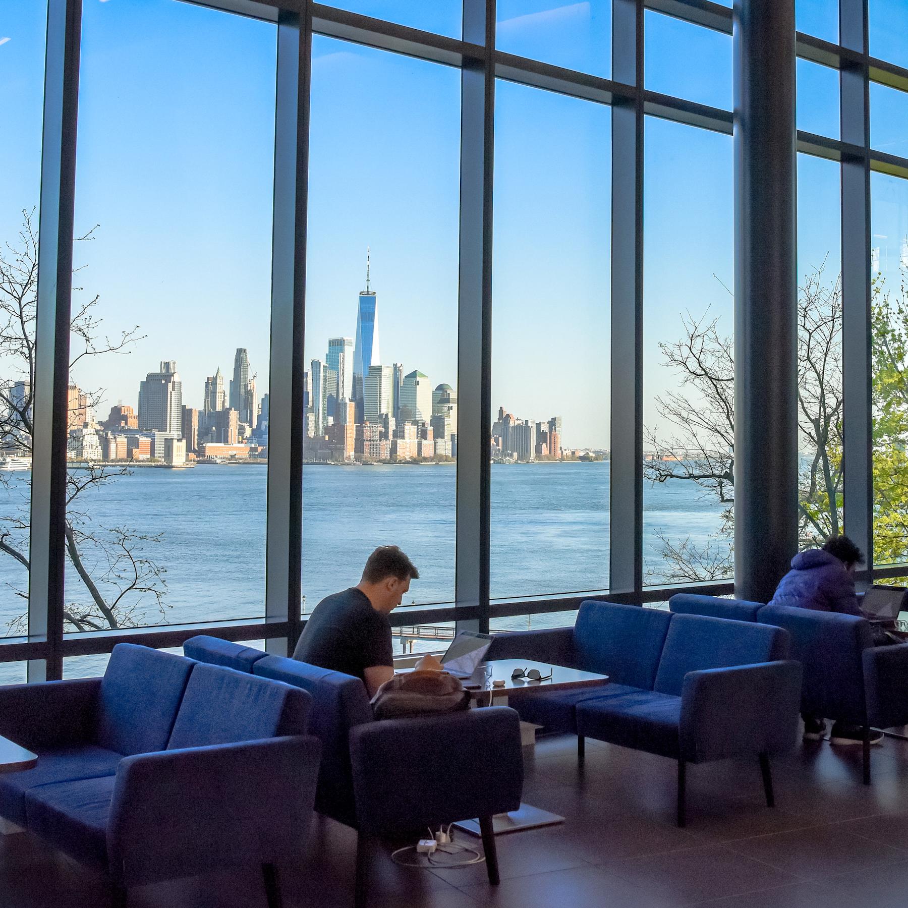 Student studying inside the UCC with the Manhattan skyline in the background.