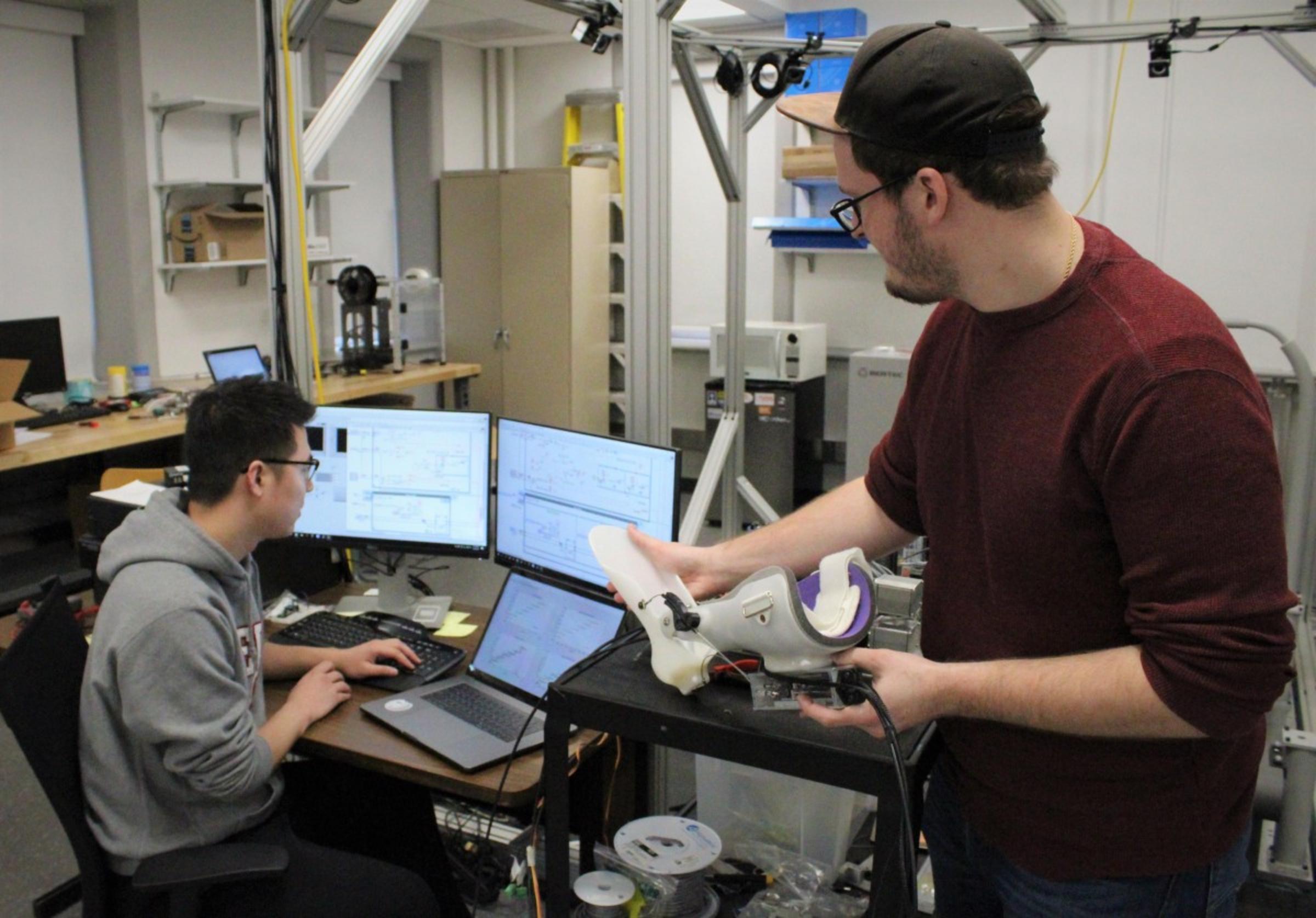 Zhang and Kleinmann in the lab working on the orthotic
