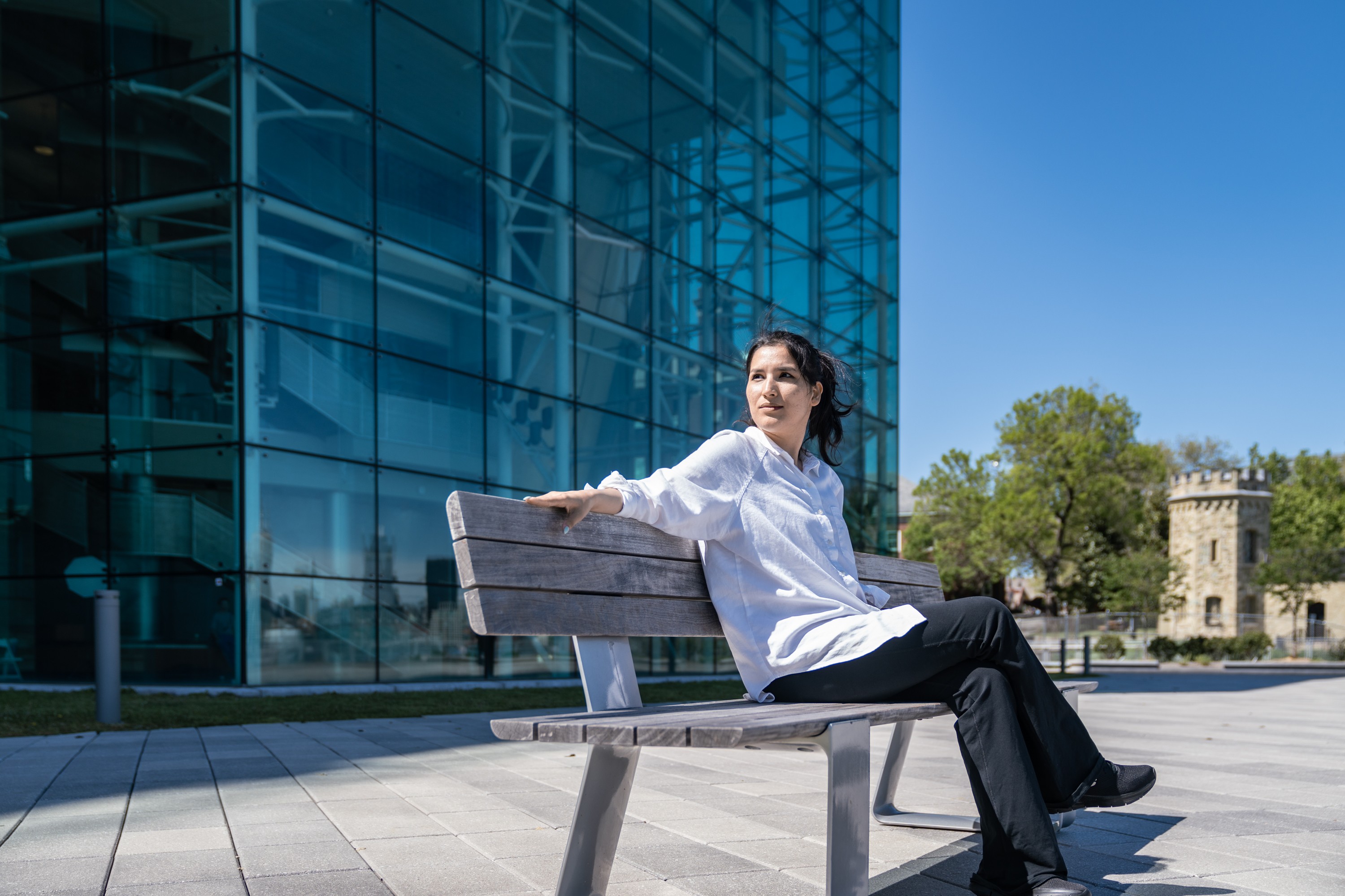 Seddiqa Hussein sitting on a bench outside