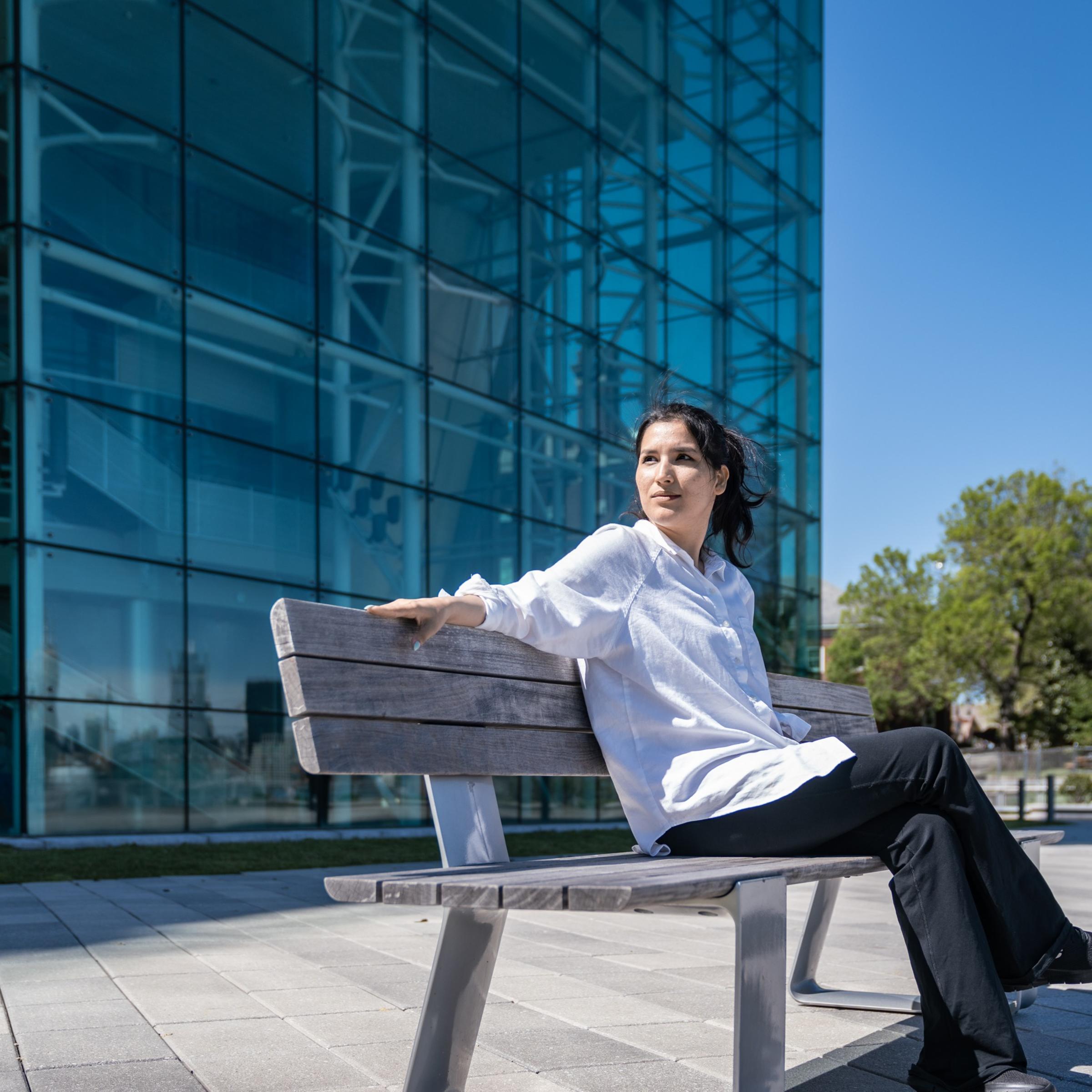Seddiqa Hussein sitting on a bench outside