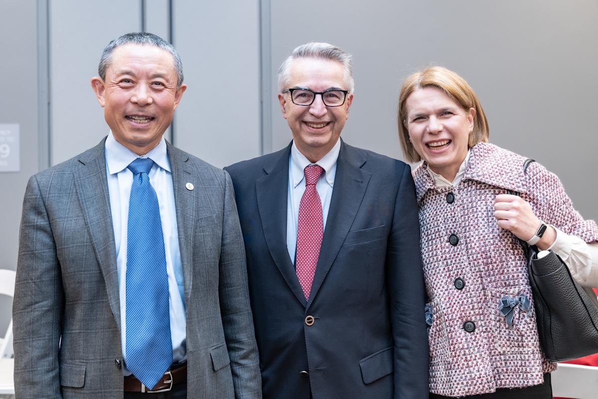 Gregory Prastacos stand between Jianmin Qu and his wife, Olympia. 