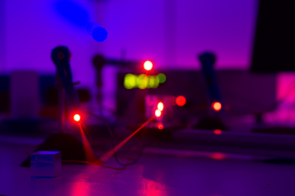 Two red laser beams intersect in a dark room