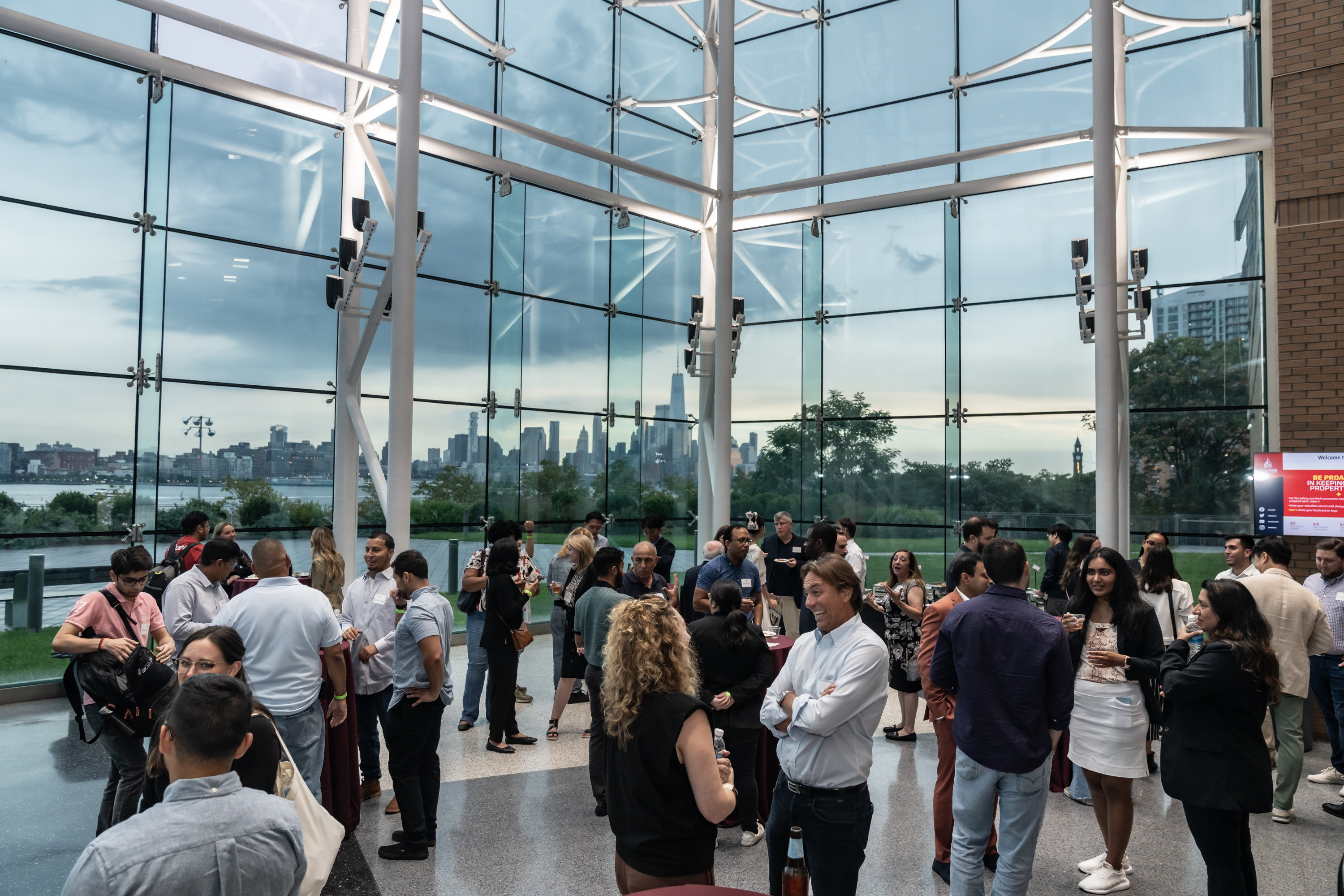 Photo of networking reception with the New Your City skyline in the background.