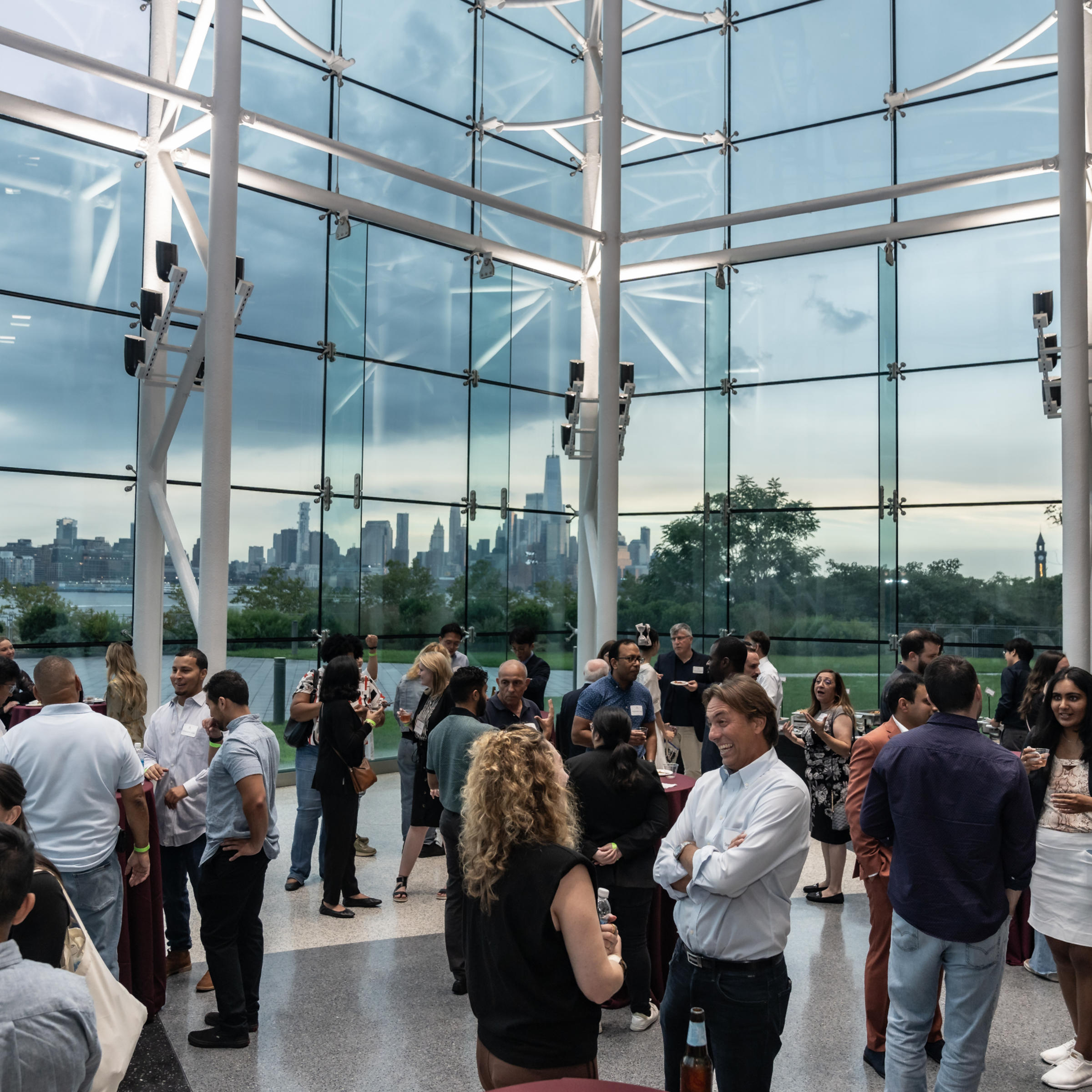 Photo of networking reception with the New Your City skyline in the background.