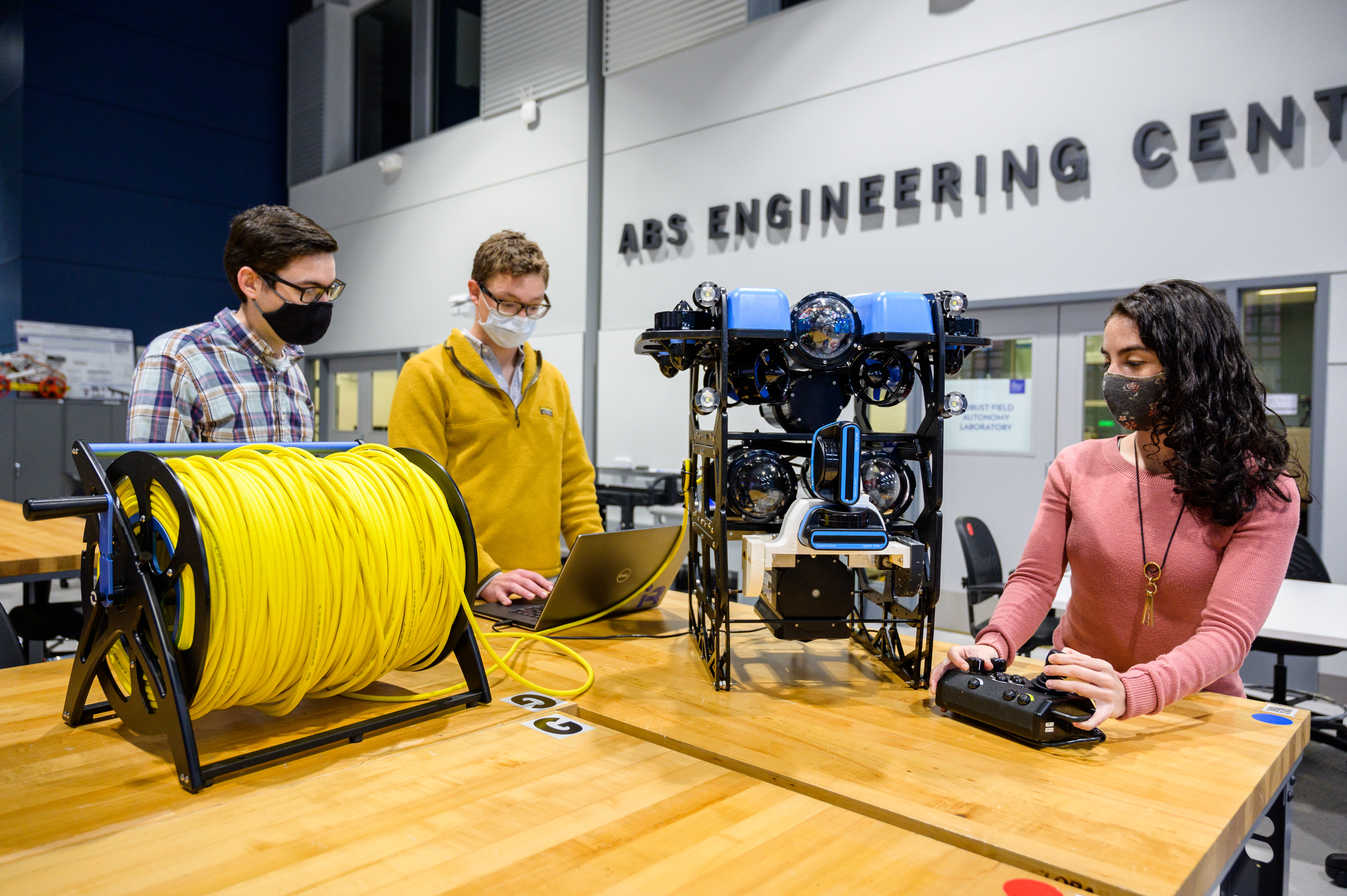 Three students work on underwater drone in the ABS Engineering Center.