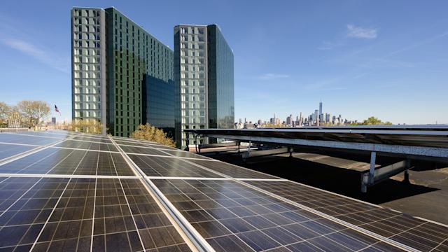 Solar panels on Stevens campus with the city skyline and two residential towers in the background