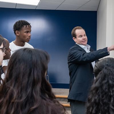 Professor at white board teaching with students