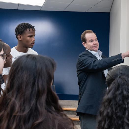 Professor at white board teaching with students
