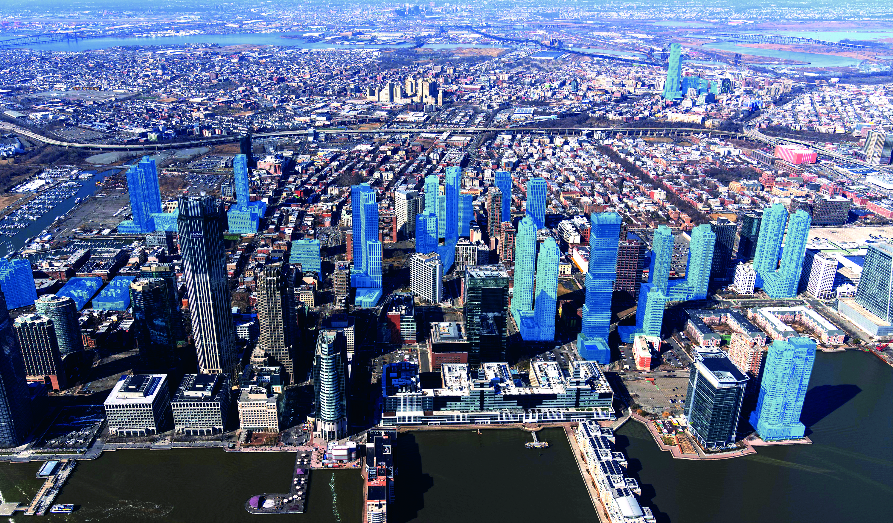 A bird’s eye view of the Jersey City Skyline on a clear day. Toward the middle of the photo, more than a dozen of the city’s buildings are shaded in light blue to denote the properties that alumni Anthony Diaco’s company has built.  