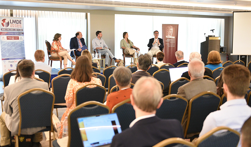 4 LMDE presenters are on the stage and speaking to a group