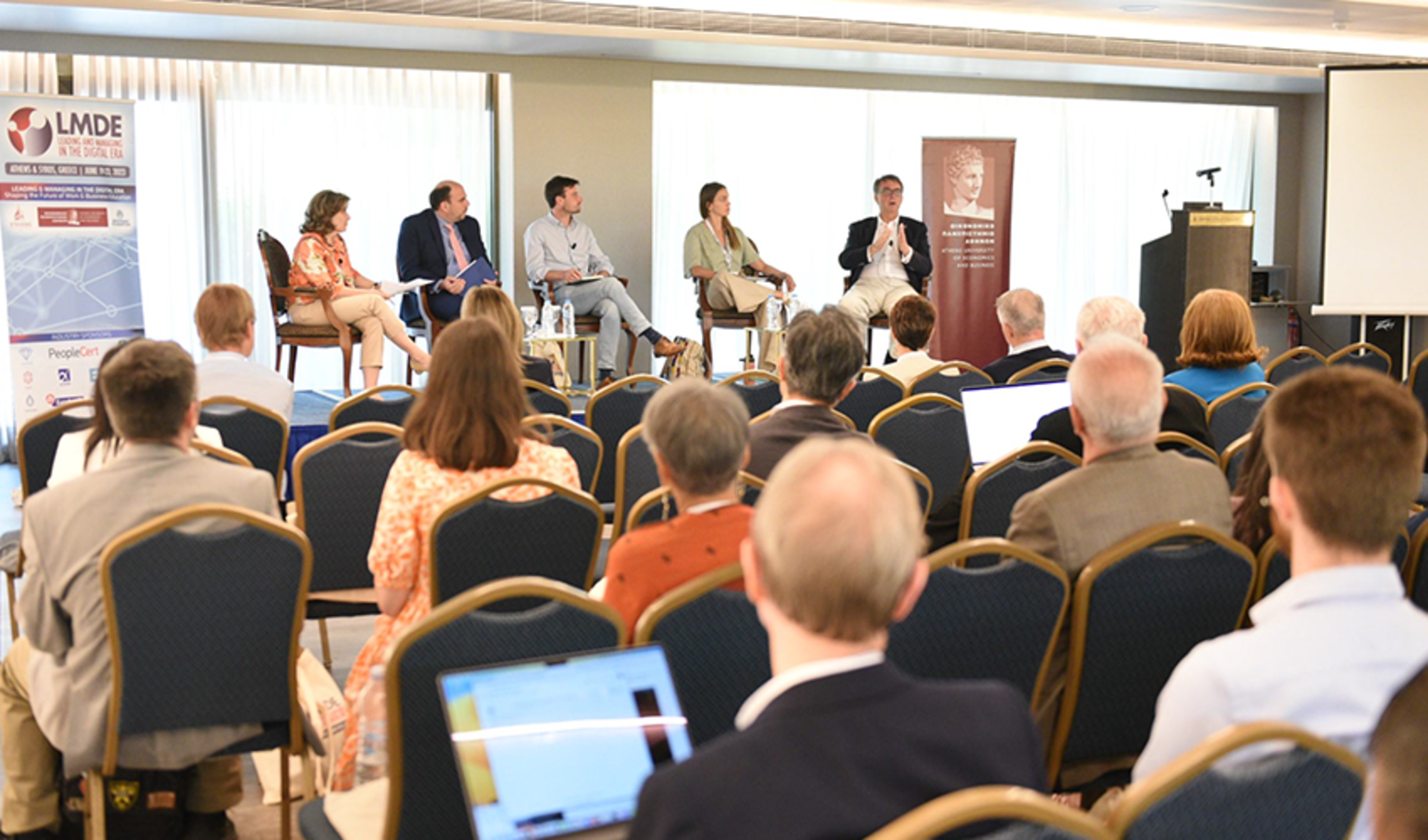 4 LMDE presenters are on the stage and speaking to a group