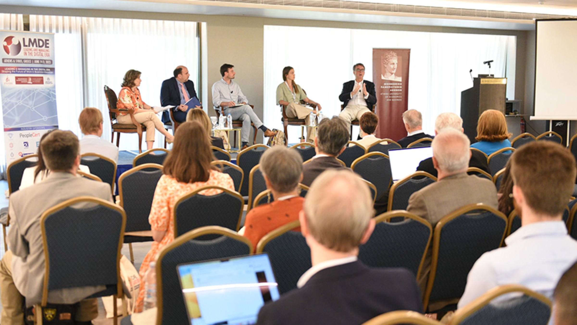 4 LMDE presenters are on the stage and speaking to a group