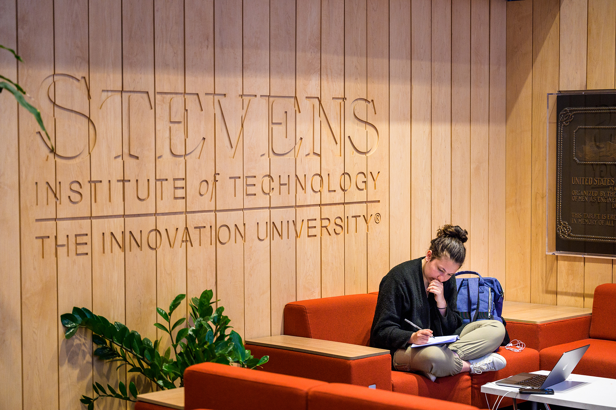 Student on sofa writing