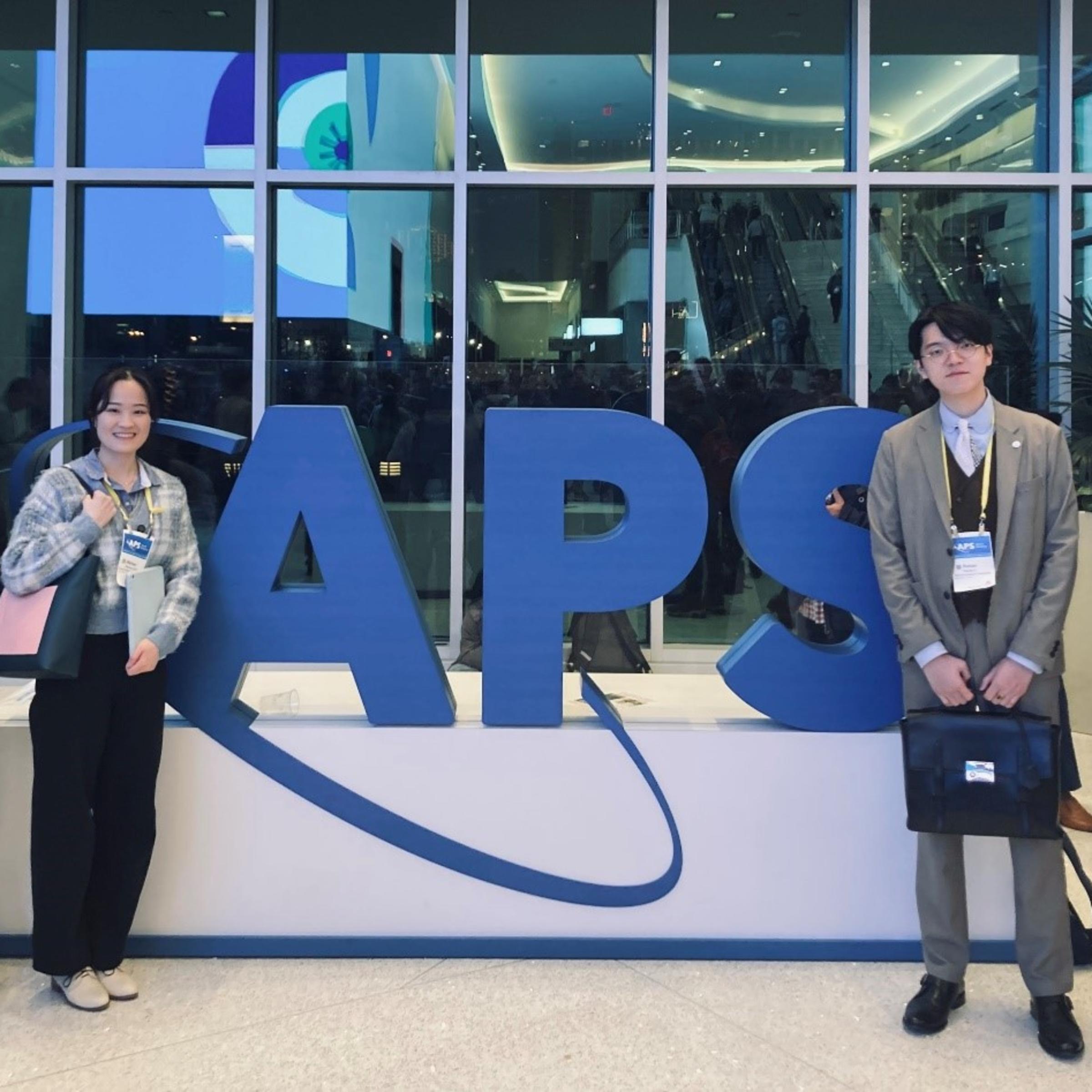 Several Stevens students stand in front of a big APS sign.