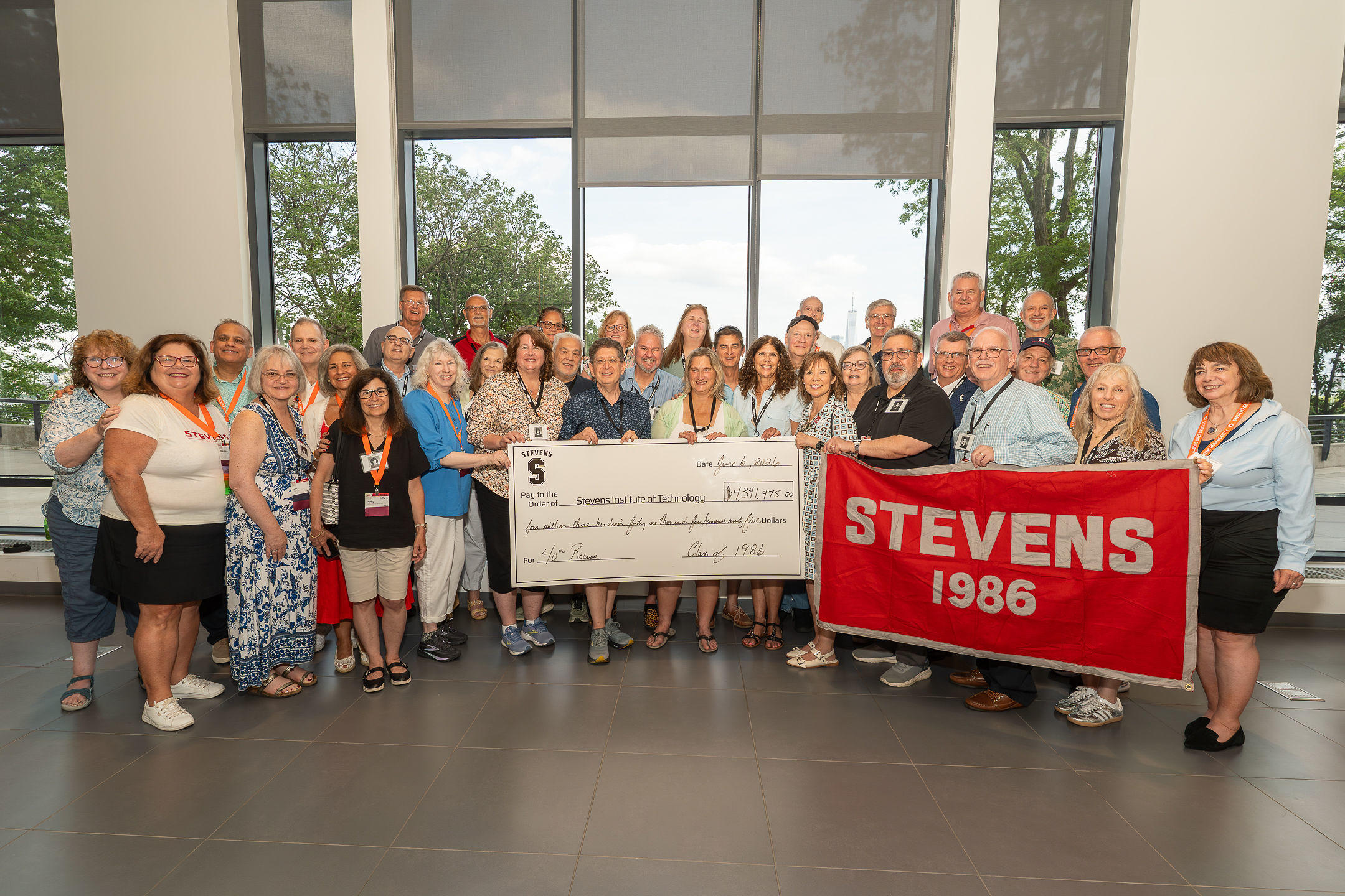 Members of the Class of 1986 pose for a group photo with novelty check at 40th reunion