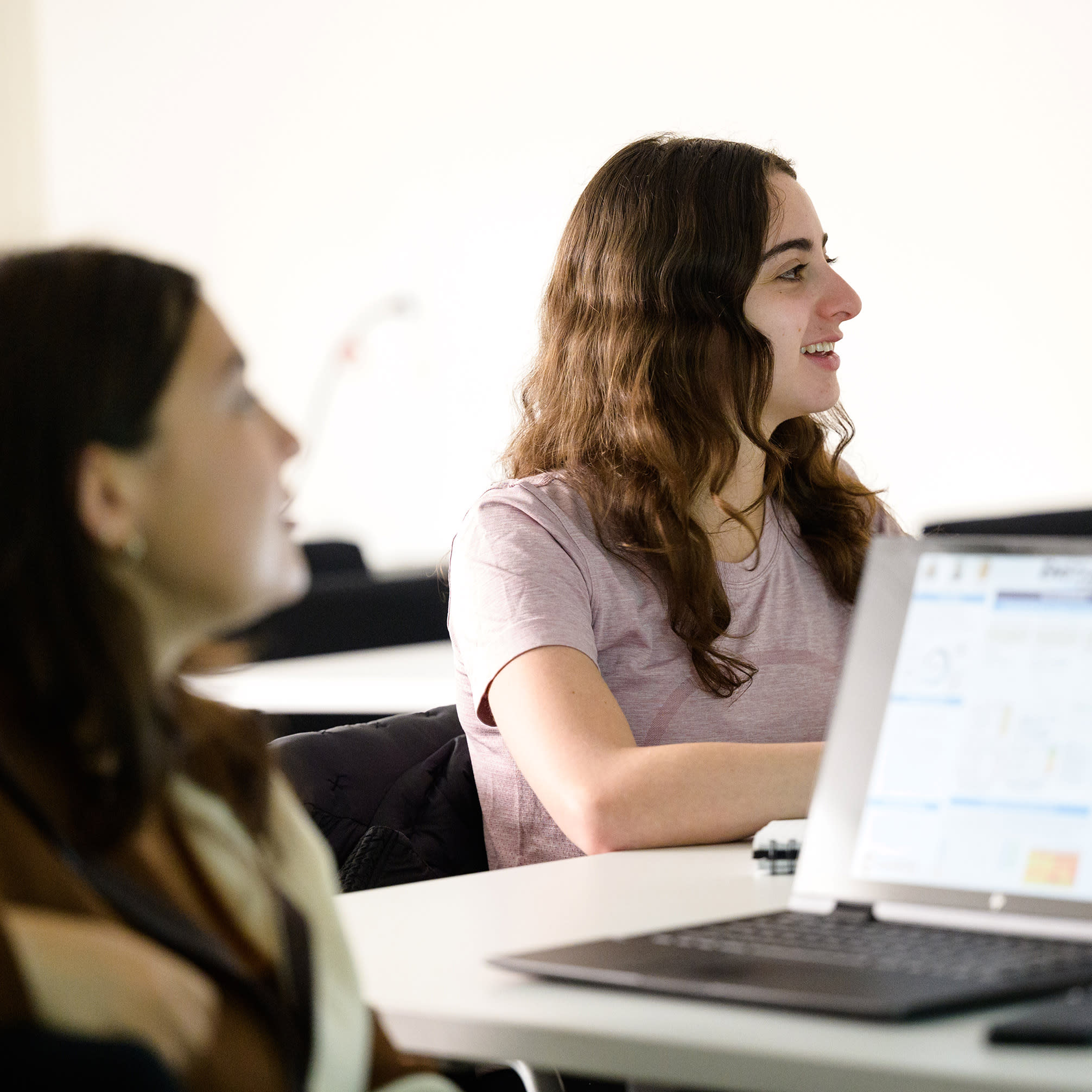 Student smiling listening to a lecture.