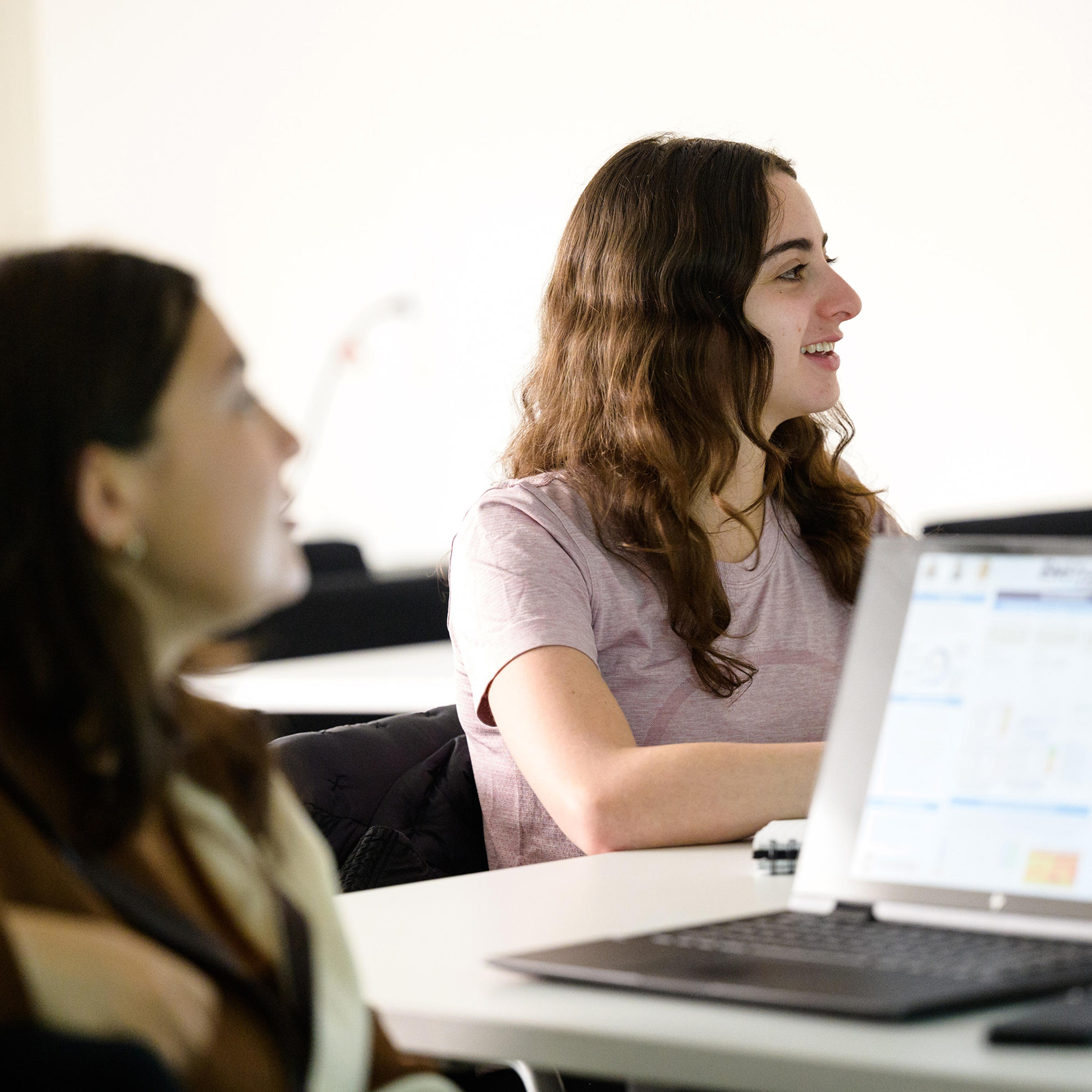Student smiling listening to a lecture.