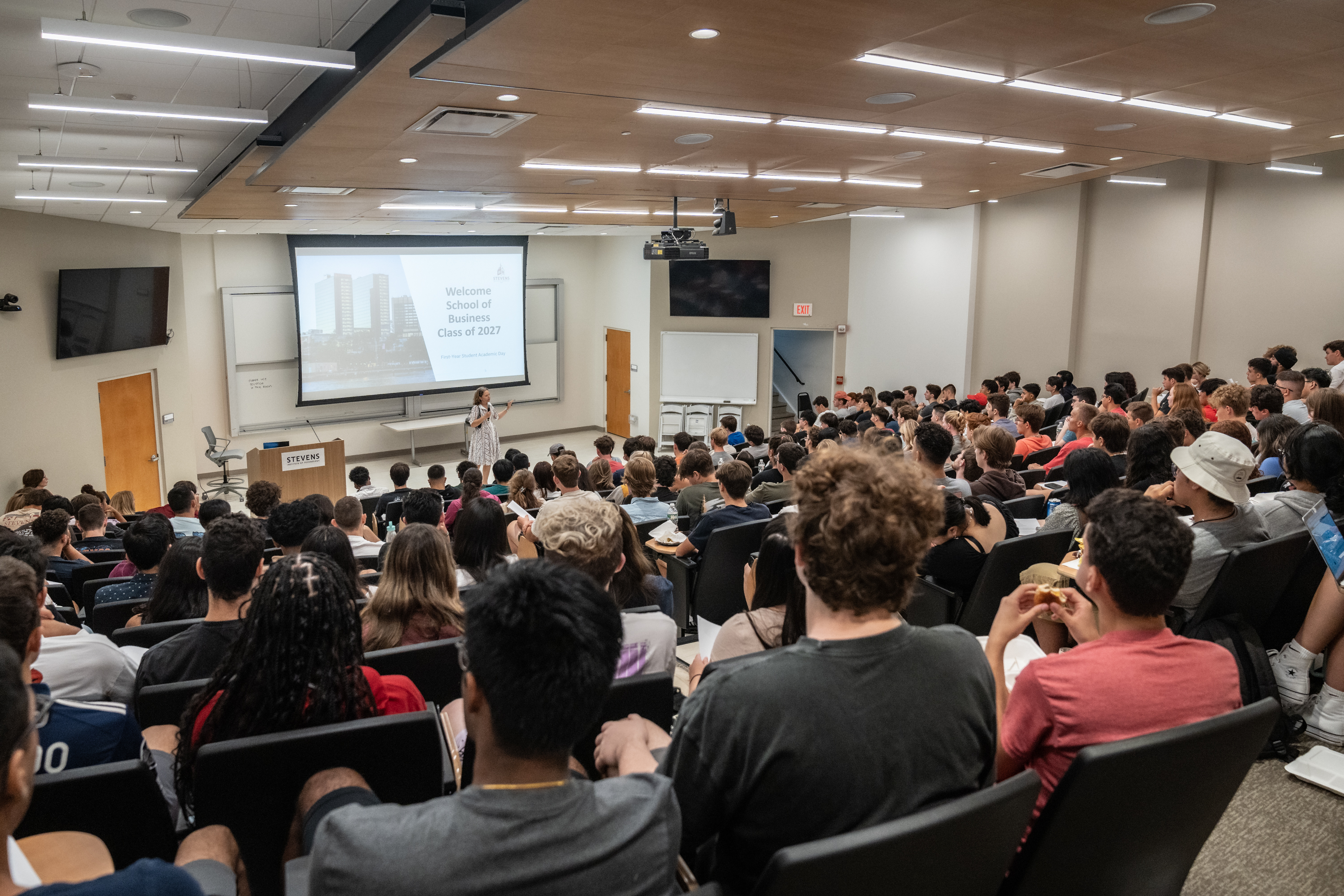 Joelle Saad-Lessler speaks in front of group of first-year students in large auditorium