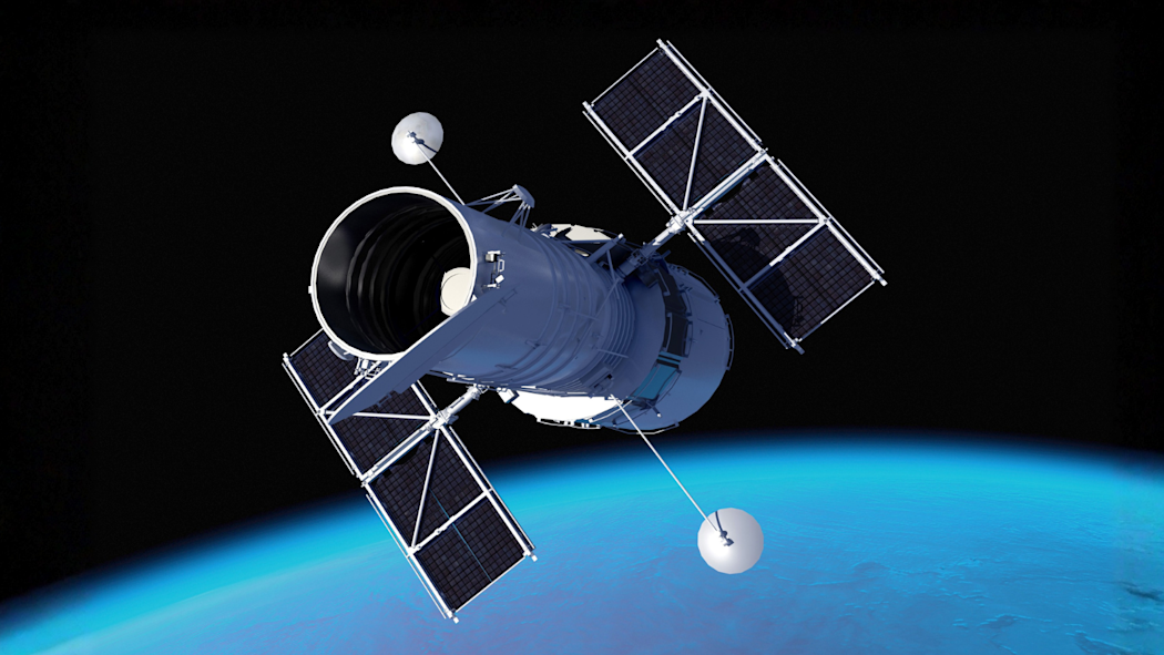 A photograph of the Hubble Space Telescope floating in outer space.