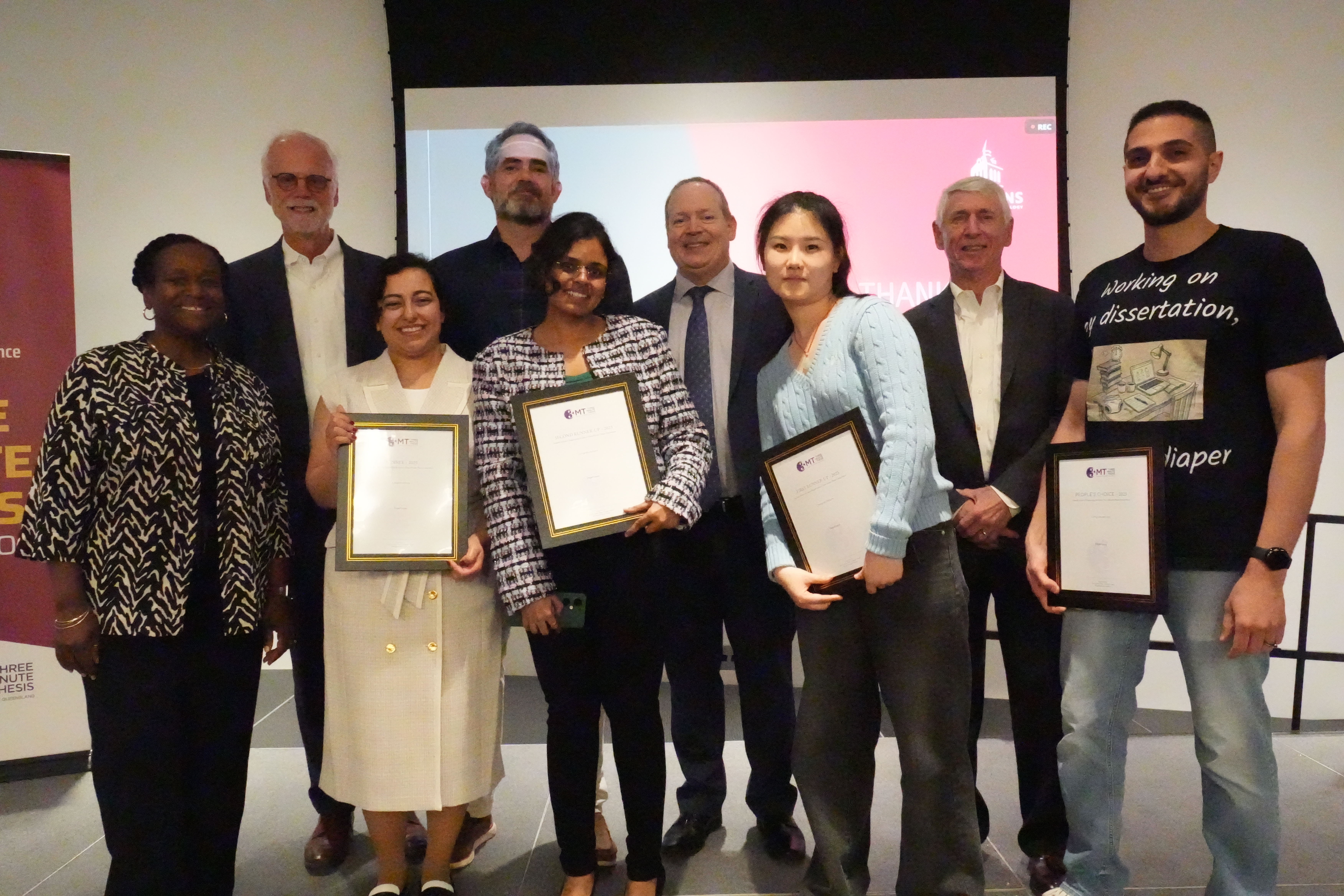 A group of students stand with Rainer Martini holding their certificate awards.