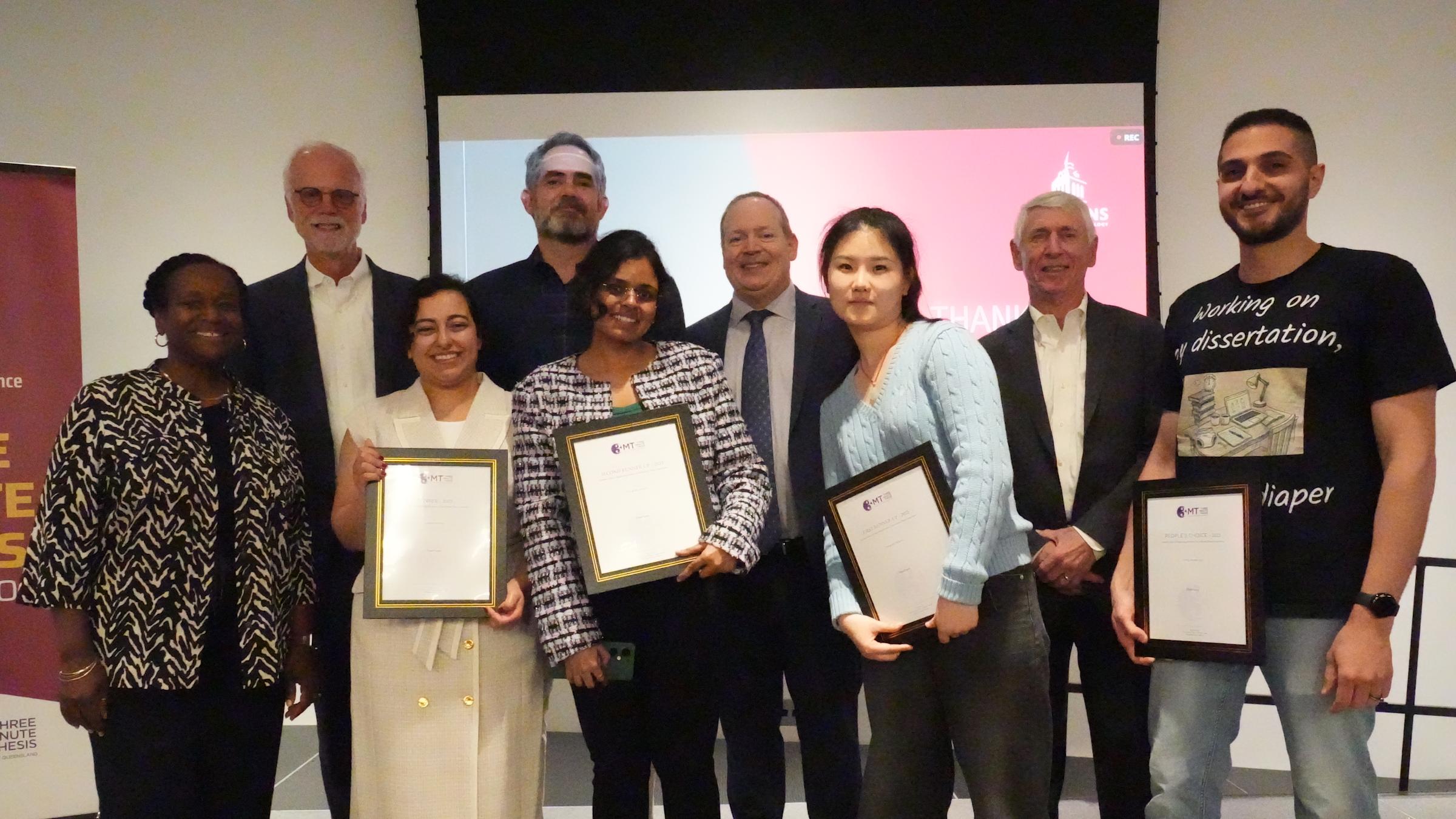 A group of students stand with Rainer Martini holding their certificate awards.