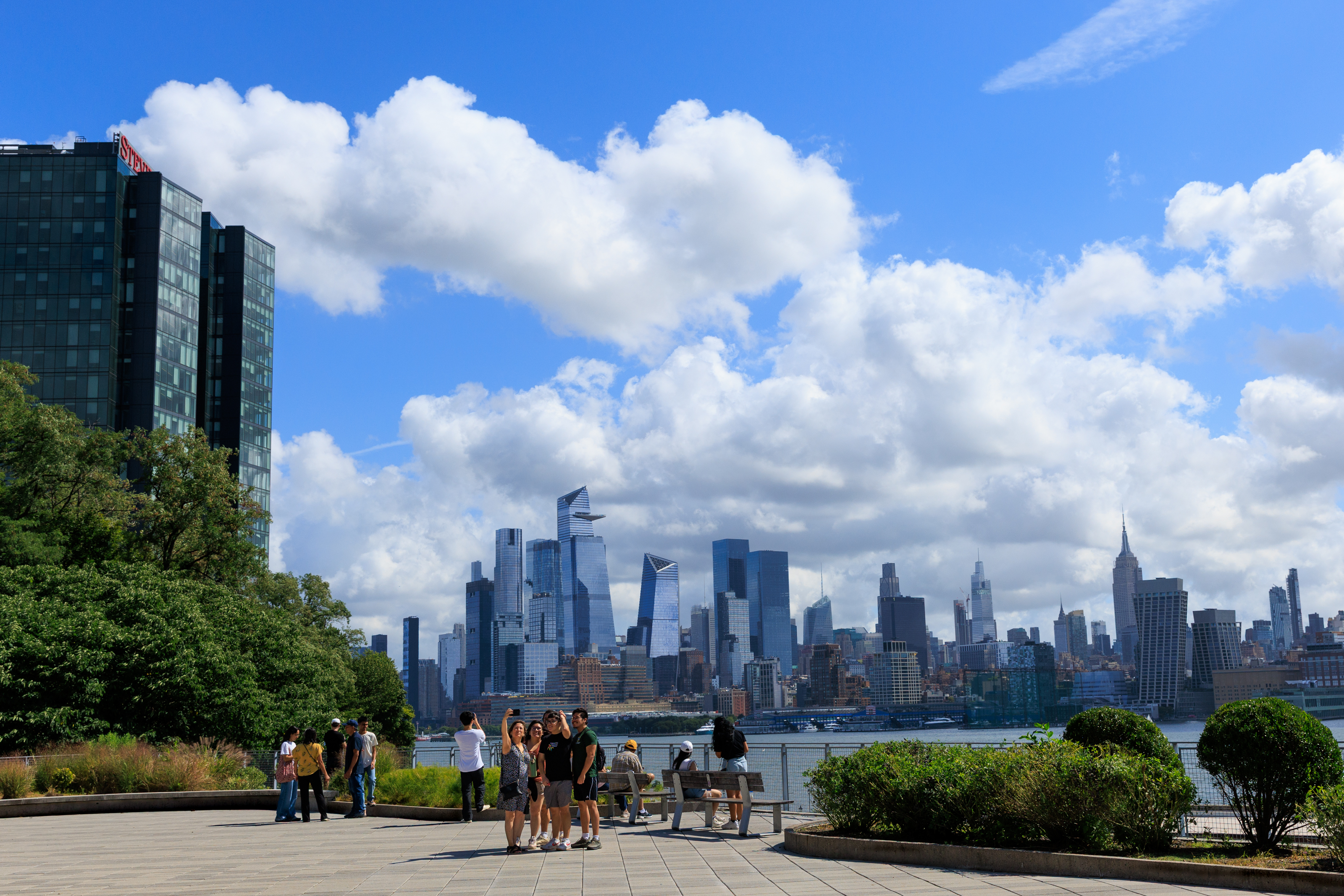 People take selfies in front of the Manhattan skyline 