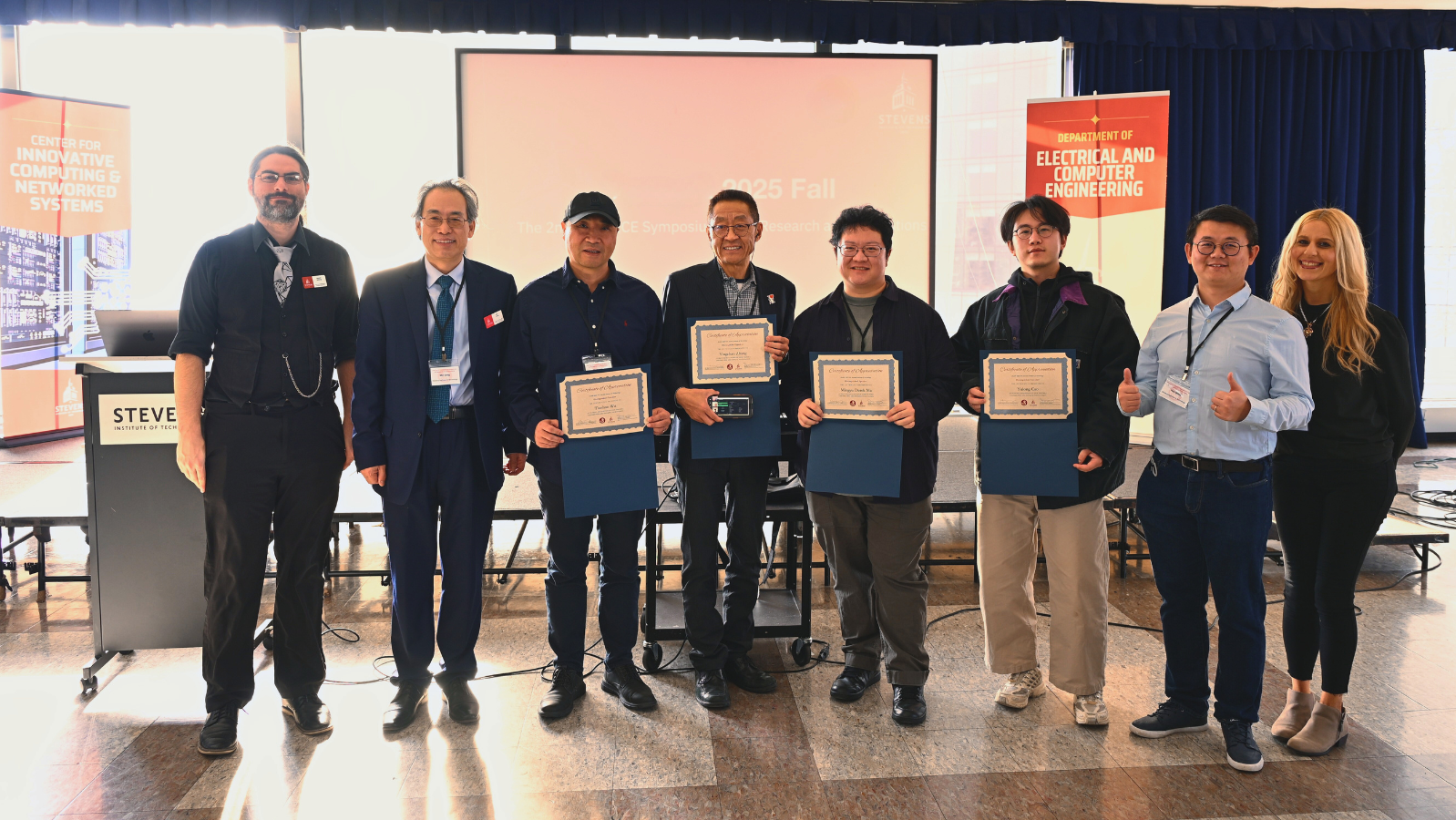 iCNS AI Engineering and Science Symposium speakers (from left) Joseph Helsing, Min Song, Tianhao Wu, Yingchao Zhang, Mingyu Derek Ma,  Yulong Cao,  Hao Wang and Jessica Gruich standing in front of a stage and podium.