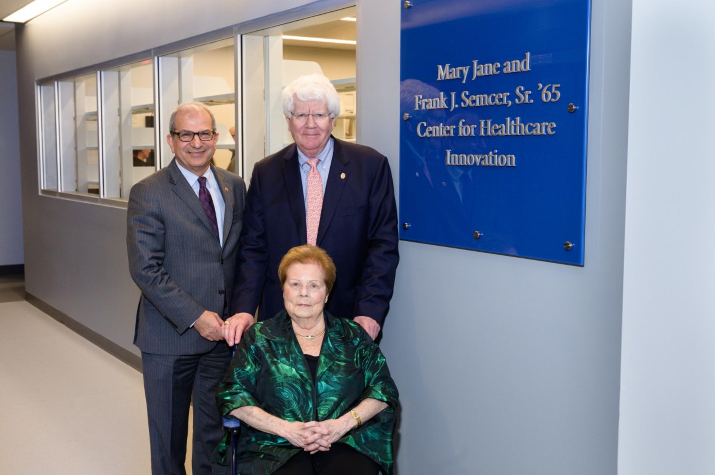 Donors with president and a sign