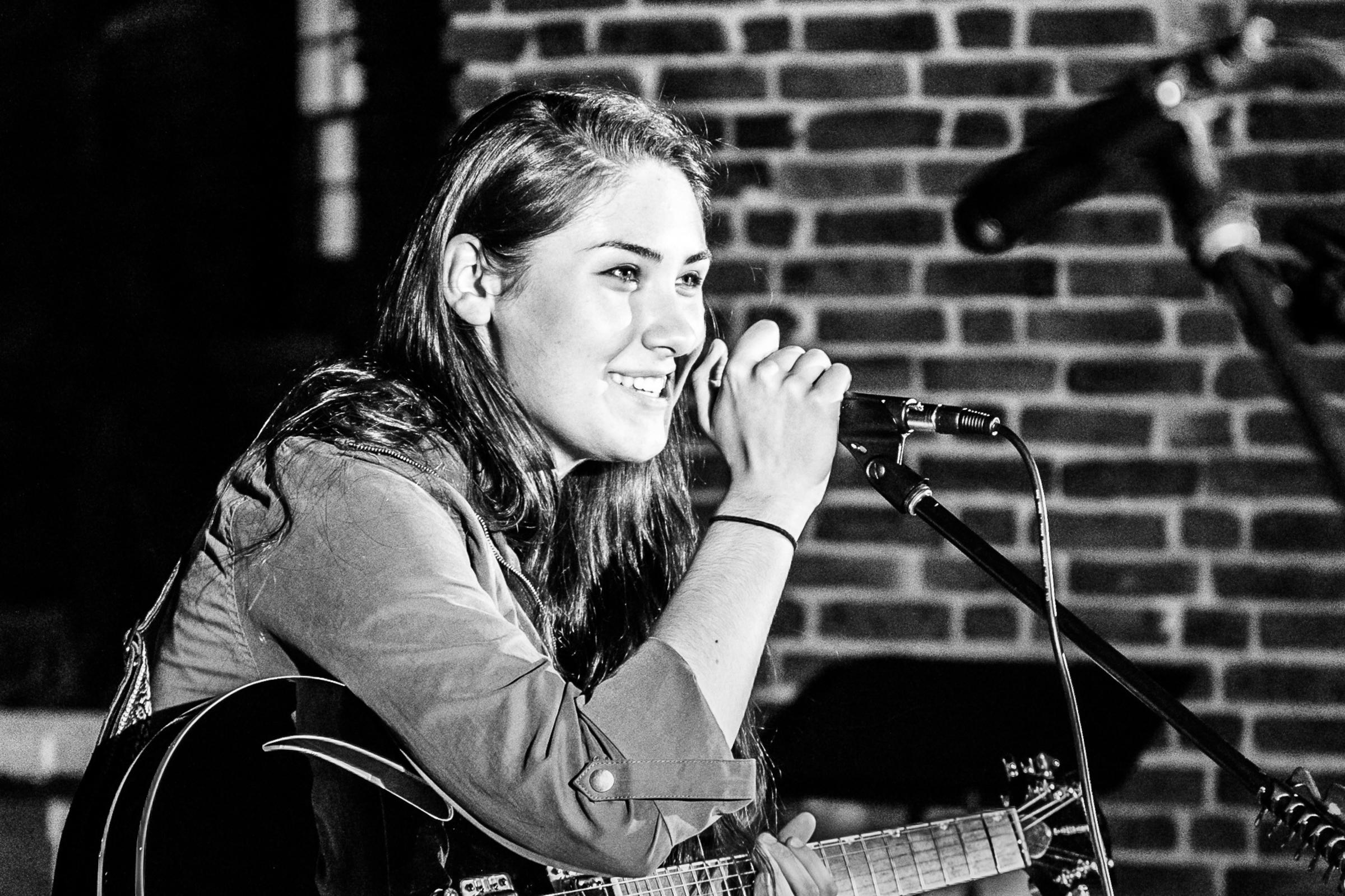 Female student singing at open mic night