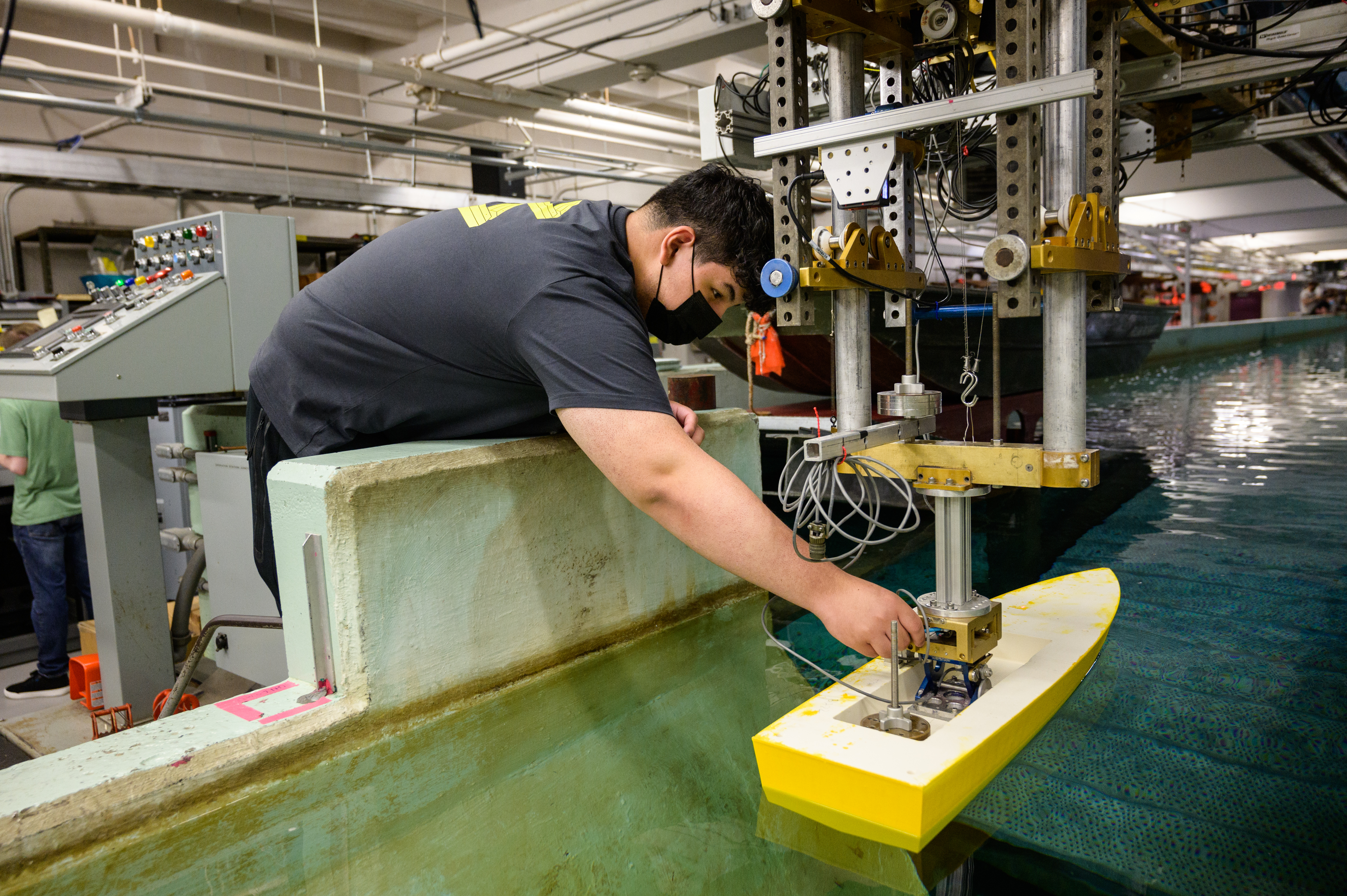 student testing a boat model in Davidson Lab wave tank
