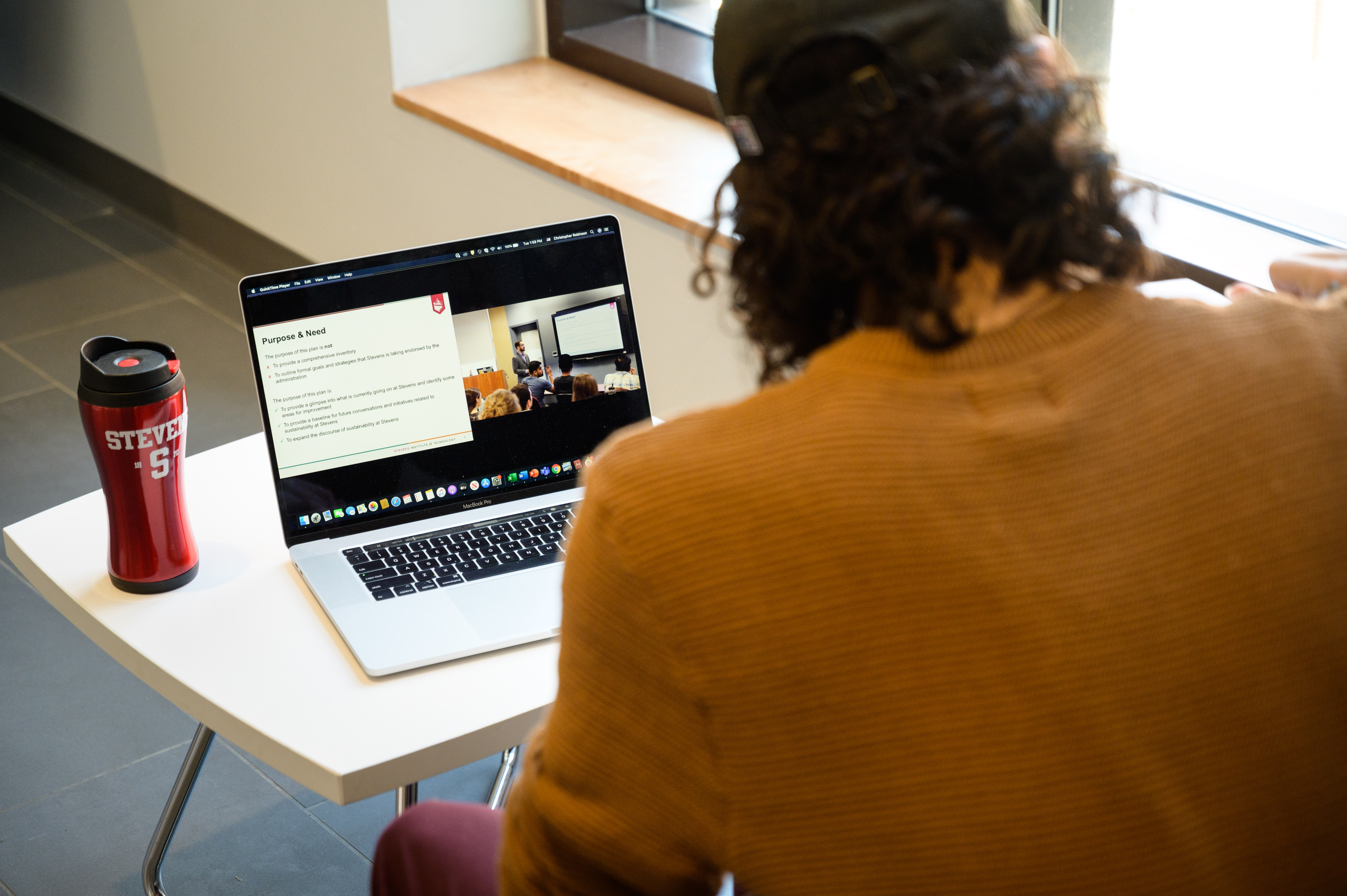 A student watches a lecture on his laptop.
