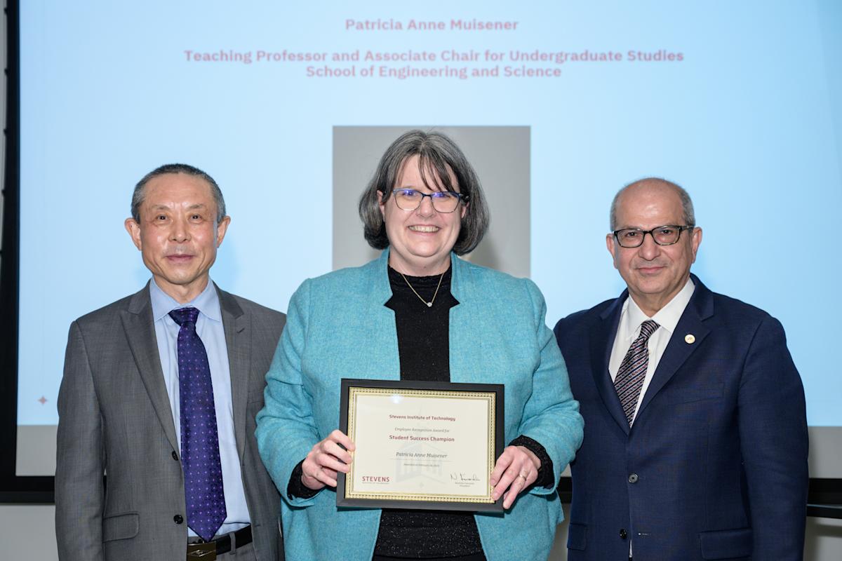 Patricia Muisener and David Zeng stand next to each other holding an award. The shot is from the waist up.