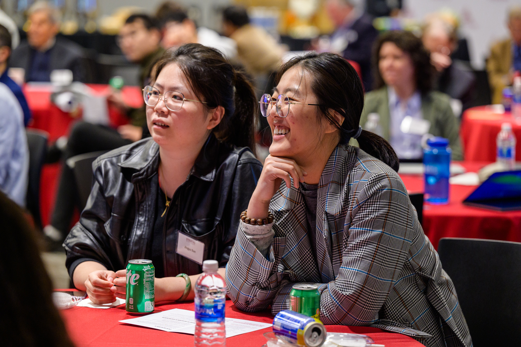 Attendees seated at tables during the CHI Relaunch event, with drinks and materials in front of them.