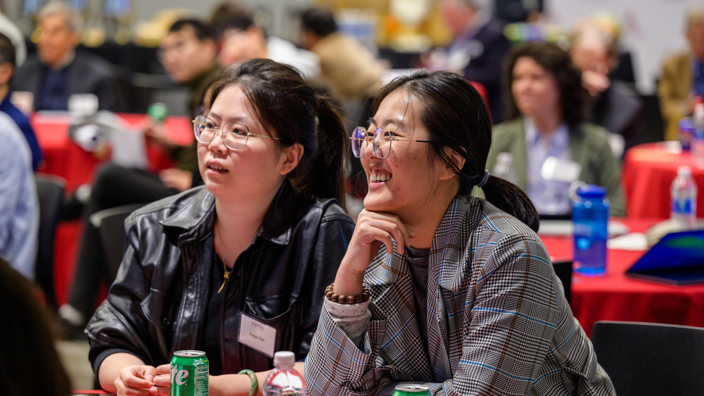 Attendees seated at tables during the CHI Relaunch event, with drinks and materials in front of them.