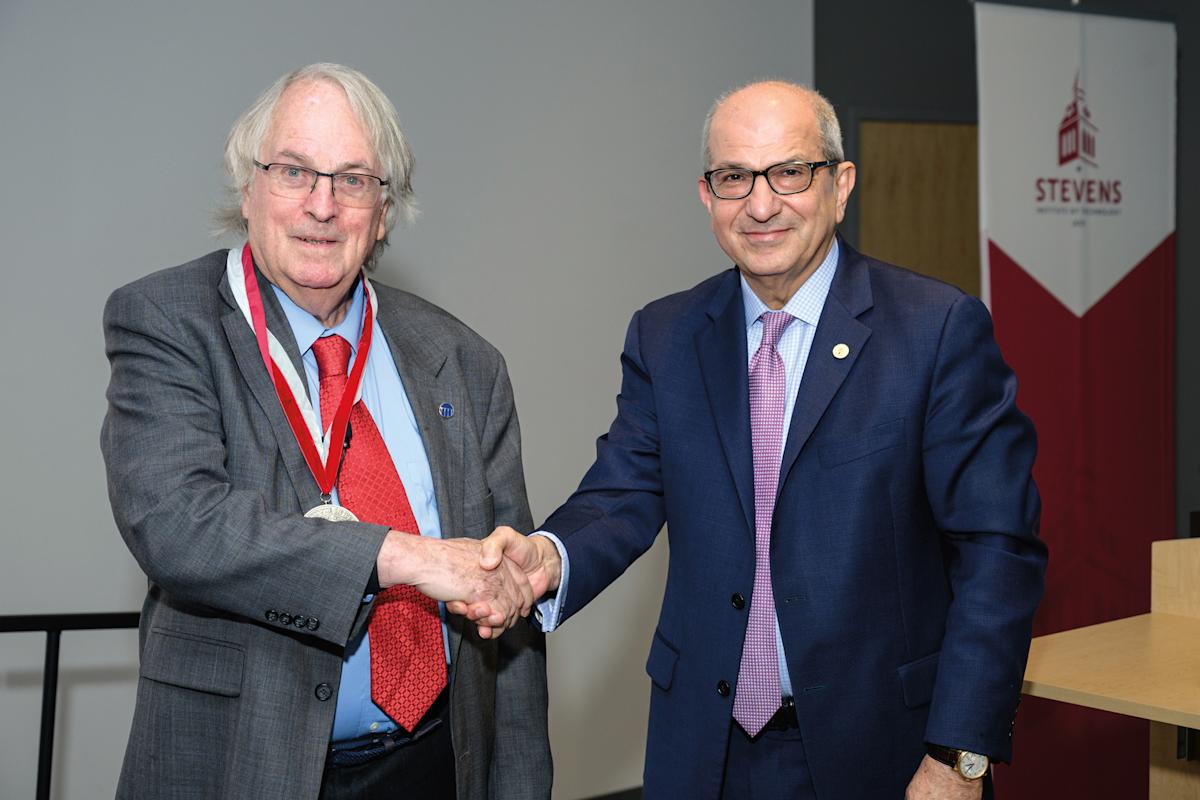 Photo of M. Stanley Whittingham, left, shaking hands with Stevens President Nariman Farvardin.
