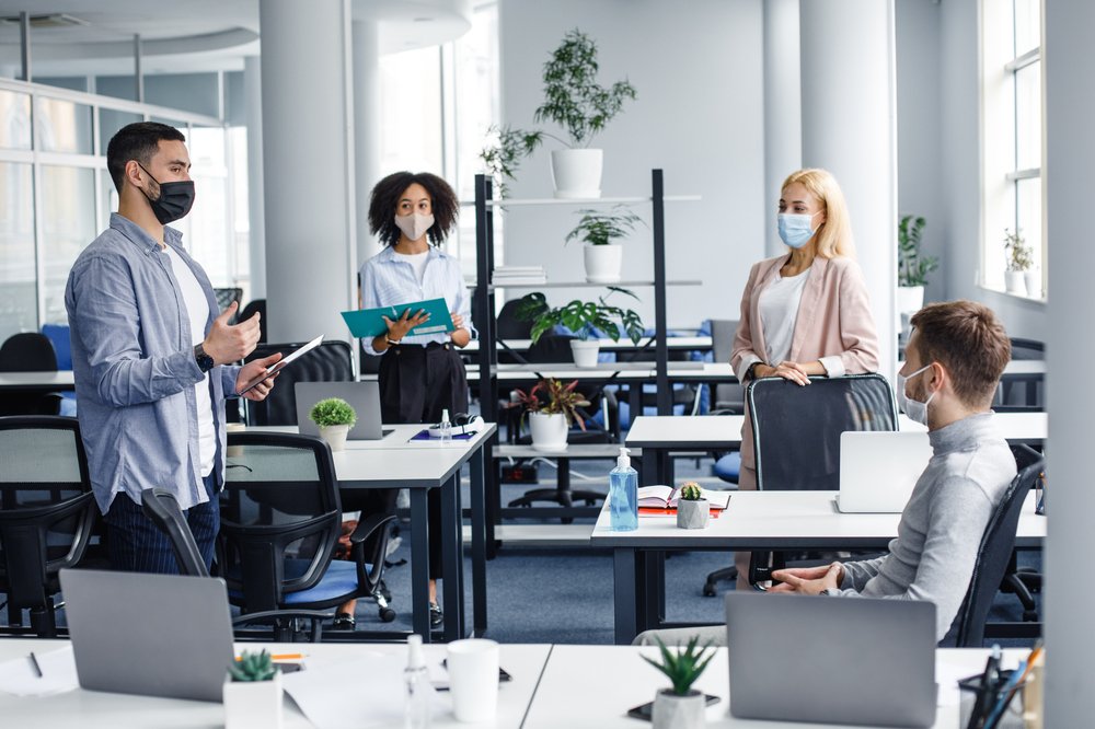 Meeting and reporting on project or team building by employees and boss in office interior with devices
