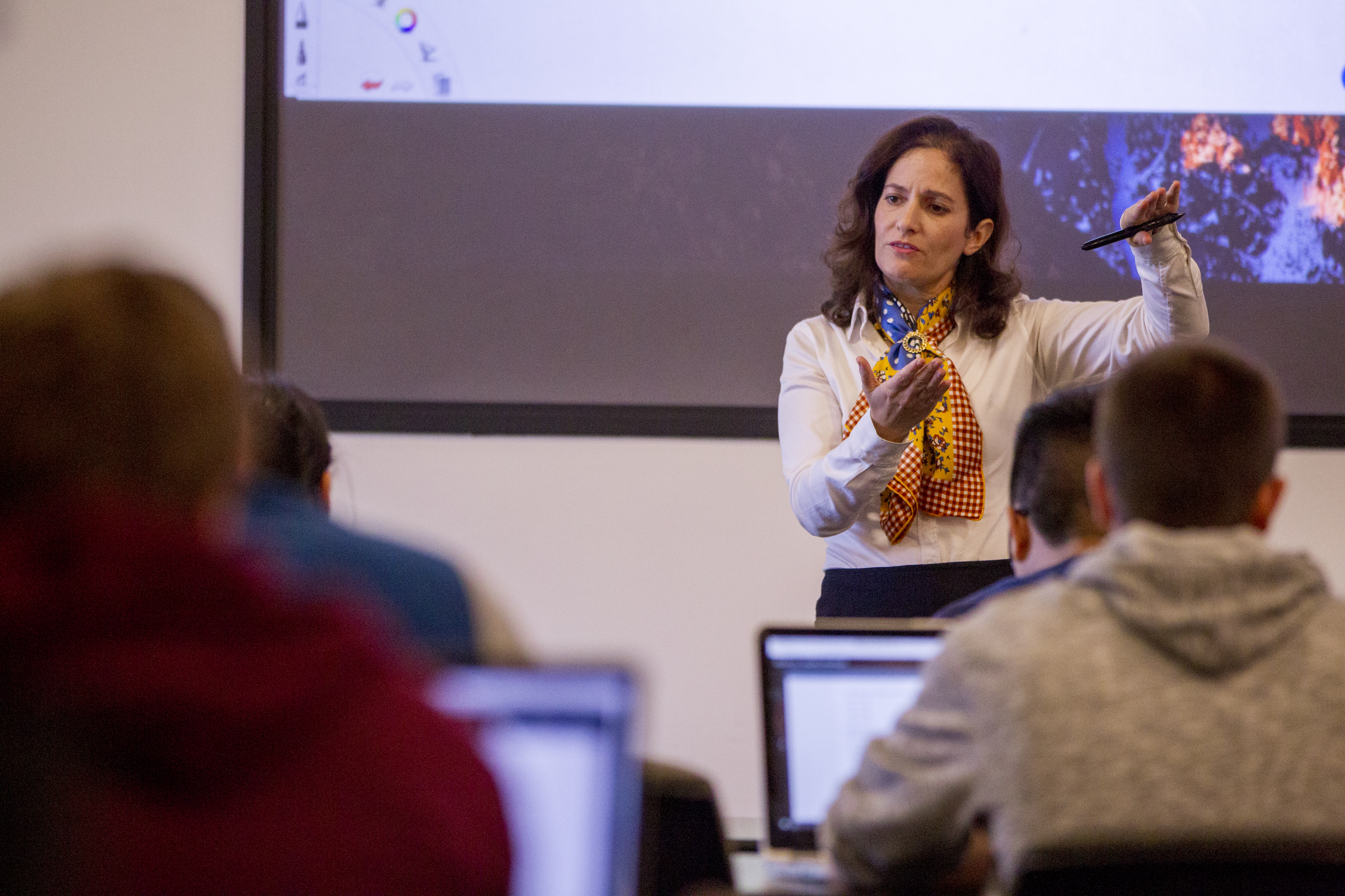Joelle Saad-Lessler stands at the front of a classroom teaching