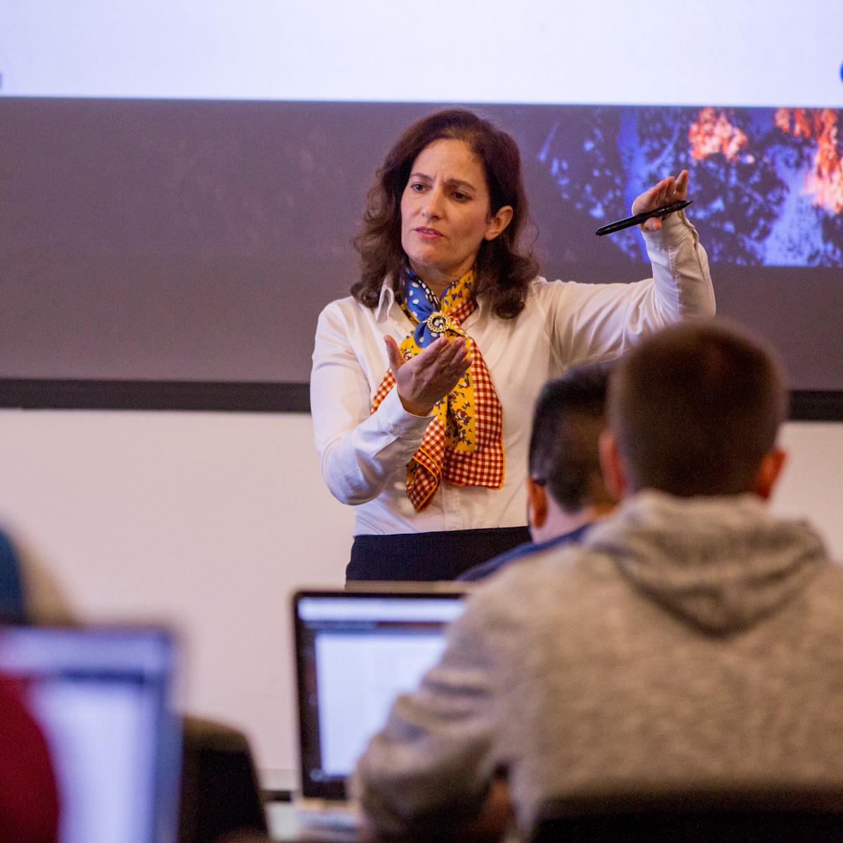 Joelle Saad-Lessler stands at the front of a classroom teaching