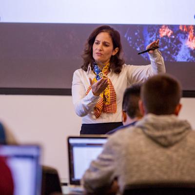 Joelle Saad-Lessler stands at the front of a classroom teaching